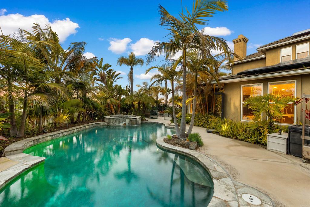 This stunning property at 6497 Wayfinders Ct. in Carlsbad CA is located in the small enclave of Surfpoint Fine Homes (same builder as Bay Collection), truly stands out with its luxurious and thoughtful design, making it an entertainer's dream and a haven for comfortable living. One of the standout highlights is the primary suite conveniently located on the first floor (two story that lives like a single story), offering easy access and privacy, complete with elegant marble counters in the primary bath for that spa-like feel. The heart of the home is an open kitchen and family room, boasting high-end Thermador appliances, marble counters, and a custom-built kitchen banquette that's perfect for casual meals or gatherings. Adding to the sophistication are Hunter Douglas PowerView shades for effortless light control. The backyard is a true tropical oasis, transformed with more than 50 palm trees that create a lush, resort-style escape. It features a thermal panel-heated Pentair-controlled pool and spa, custom lighting, a built-in bar with a new Lion built-in grill for seamless outdoor cooking, and a putting green for fun leisure activities. The custom-built palapa provides shaded seating, and the crescent-shaped layout ensures ultimate privacy while framing breathtaking ocean views through protected open space. Imagine hosting evenings here with front-row seats to the Legoland fireworks shows—it's designed for unforgettable backyard entertaining. Inside, practicality meets luxury with a private office equipped with a temperature- and humidity-controlled custom wine refrigerator that can store up to 522 bottles and 36 magnums, ideal for any wine enthusiast. Sustainability is key too, with fully owned solar panels to keep energy costs low and efficient, plus a Tesla EV wall charger for convenient plug-and-go charging. Situated in a double cul-de-sac within a small, exclusive enclave of just 21 homes, the property offers a serene, private feel without sacrificing modern conveniences.