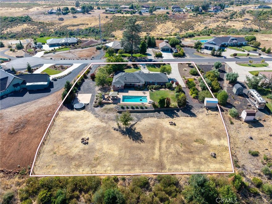 Stunning Gated Estate with Views, Saltwater Pool, and Over 2 Acres of Beauty – Just Outside of Chico!
Located at the end of a quiet cul-de-sac in the premier gated community of Blue Oak Terrace, this exceptional property offers the perfect blend of luxury, privacy, and functionality on just over 2 beautifully landscaped acres with panoramic views of the valley and mountains. Within the neighborhood, the southside of Tuscan Drive offers a highly desirable, serene setting.
Inside, you’ll find travertine and wood flooring in the main living areas, arched doorways, high ceilings, and floor-to-ceiling windows that perfectly frame the view. The spacious living room includes a beautiful fireplace and custom tray ceilings, flowing into a well-appointed kitchen with bar-top seating, granite countertops, newer appliances, and stunning knotty alder cabinets. The dining area overlooks the pool, making it perfect for entertaining. The thoughtfully designed split floorplan includes an office, two guest bedrooms, and a full guest bathroom with direct pool access on one side of the home, while another guest bedroom, full bathroom, and the primary suite are located on the other. The expansive primary suite is a luxurious retreat with private spa/patio access, dual walk-in closets, and an en-suite bathroom featuring a soaking tub, large walk-in shower, and dual vanities.
The outdoor space is truly impressive—featuring a gorgeous saltwater pool, lush front and back lawns, an outdoor fireplace, built-in basketball court, and an additional driveway offering ample parking for all your toys. The grounds are dotted with vibrant flowers, fruit trees, olive trees, and multiple areas ready for gardening. A new 10x18 shed, and fully redone automated irrigation system add convenience and fun. The entire property is fenced and includes snake guards for added peace of mind.
Additional highlights include owned solar, dual-zone HVAC with two thermostats, a whole house fan, designer lighting and transom windows throughout, a large laundry room, and a three-car garage with new openers and rubber garage mats. The exterior was freshly painted with high-quality elastomeric paint, and the pool has been updated with a brand-new saltwater chlorinator and pool cover.
This home is truly move-in ready and offers the perfect setting for relaxing, entertaining, or simply enjoying the peaceful surroundings. Don’t miss your chance to own one of Chico’s most stunning estates!