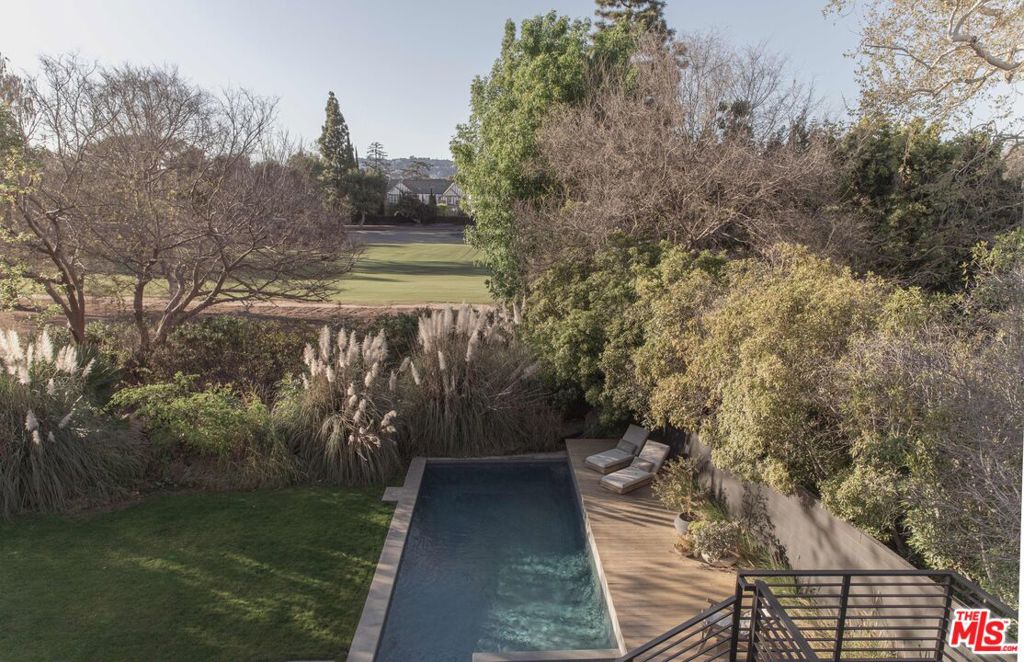 Rare, warm modern architectural retreat in prime Hancock Park. Over 1/3 acre of total privacy, including a bubbling creek, all overlooking the 8th Fairway of Wilshire Country Club and views extending beyond to the Hollywood Hills. Enter a serene world reminiscent of California wine country yet situated on a private cul-de-sac in a most prime location. This stunning architectural residence spans over 6,000 square feet of meticulous design and execution of the highest quality, rarely found on the market today. Flooded with natural light, beamed and vaulted ceilings, and a carefully designed layout that flows effortlessly to the outside for perfect indoor-outdoor living and entertaining. From the chef's kitchen to 6 bedrooms culminating in a primary suite that is a world unto itself. This has it all, including state of the art air filtration and water purification systems. A truly special and rare offering.