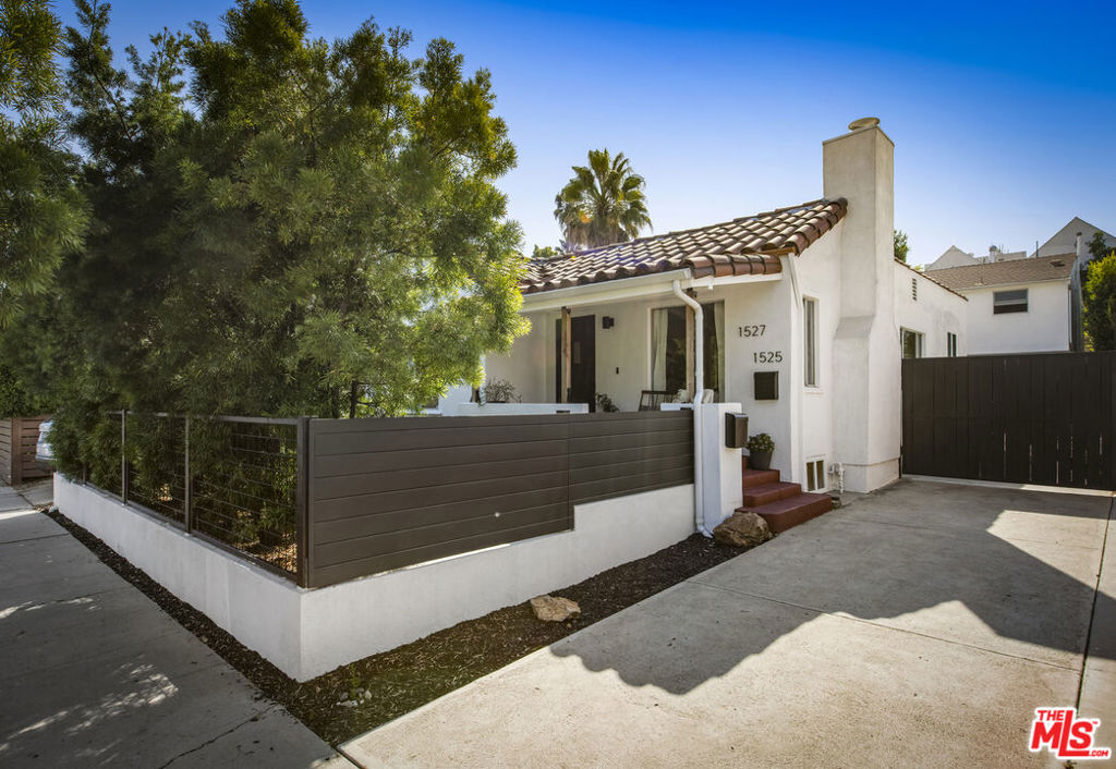 Privacy and charm are found in this Picfair Village duplex that is 100% vacant. Behind a tall Podocarpus hedge with hog wire fence topped wall you will be welcomed by a covered front porch, the perfect spot to enjoy that morning cup you picked up on your stroll to Mad Lab Coffee. This enchanting Spanish 2 bed + 2 bath home with detached freestanding 1 bed + 1 bath unit on the 2nd floor of the rear of the property has so much to offer and more. In addition, you will discover under the back unit are two additional flex spaces, one with full bath and laundry. Through the front door you will discover a spacious living room with gas fireplace. This room adjoins a formal dining room with period built-in buffet that has been outfitted with newer doors/drawers. Adjacent to the dining room you will find a generous sized eat-in kitchen. The kitchen offers incredible amounts of countertop space to spread out your ingredients for the many dinners you will host in this fab entertainer's home. The kitchen includes updated cabinetry, granite countertops, stainless steel dishwasher, range, refrigerator and a full-sized stacked washer/dryer. Checking everyone's boxes is a kitchen that opens up to the back yard so you can view your guests/family while honing your culinary skills. Down a large central hall is a front bedroom with custom closet and drawers. Two bathrooms flank the hall. The 1st bathroom serves guests & the front bedroom, with a tub over shower. The primary bath has a separate bathtub and large shower with two pedestal sinks. The primary suite is a true retreat. The bedroom features a walk-in closet and custom built-in desk with bookcase and drawers. A perfect spot to pen your next script or song with the dreamy views of the succulent garden for your inspiration. As you leave the primary bedroom through the door to the succulent garden with Trex deck that is the perfect spot to relax after a day in the garden under the shade of a Camphor tree. Further outdoor space is set-up for dining/lounging. Upstairs you will find an east facing spacious 1 bedroom + 1 bath unit that has a very period vibe with hardwood floors throughout and outfitted with dreamy wood-stained trim, including double paned windows. In the eat-in kitchen are warm wood paneled walls with Ikea cabinetry, butcher block counter tops, range, Miele dishwasher and stove. A peaceful bedroom that faces the hill behind is adjacent to bathroom with vintage tiled tub/shower & black painted paneling giving it a very chic feel. Downstairs are two flex spaces, both with French doors and each offering their own personality. The first includes a full-sized washer/dryer and deep laundry sink with cabinet where you can clean off your clogs and the hand trowel you pulled out of the newer storage shed after a day of gardening, or a place to wash your paint brushes and palette. This flex room has a very modern vibe that is set off by polished concrete floors and smooth light-colored wood paneling. Through the opaque glass door, you will discover a spa size shower with rainfall shower head. The designer choices of tile and finishes in this room are ready for your Pinterest. The other flex room with laminate flooring and recessed lighting is perfect as a studio space, gym or office. Behind the two-story rear unit is an additional open space that would be perfect as another spot for gardening or used as private yard for the upstairs unit. We said this property has it all. The vision is all yours now how to utilize all the great space this property has to offer. Other notable features in the main house are: oak hardwood floors, recessed lighting & central HVAC. Welcome to the paradise you have found in Casa Carmona. Set in the very walkable Mid-City neighborhood of Picfair Village with its annual pumpkin race, neighborhood feel, steps to local cafs and minutes to DTLA, the Westside, Beverly Hills and LAX.
