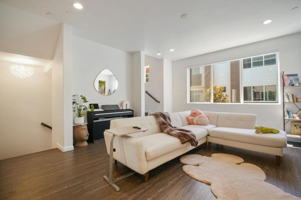 Welcome to 323 Flinder Place, a sophisticated three-bedroom, four-bath townhouse in the Santa Teresa neighborhood of San Jose. Built in 2017 with a modern architectural style, this end-unit spans 1,822 square feet across three bright, open levels. Step inside to gleaming hardwood-style flooring and vaulted ceilings that welcome sunlight through large dual-pane windows, highlighting a flexible layout perfect for everyday living and entertaining. The chefs kitchen features an island, quartz countertops, stainless appliances, and ample storage. The primary suite offers a serene retreat with a lot of natural light and electronic blinds. The unit has two full baths and two half baths to provide added convenience. Other highlights include in-unit laundry, central forced-air heating and cooling, and a two-car attached garage. With low monthly HOA dues, access to playground plus close proximity to local shopping, dog parks, and major commute routes, this townhome offers a refined, low-maintenance lifestyle in a prime San Jose location.