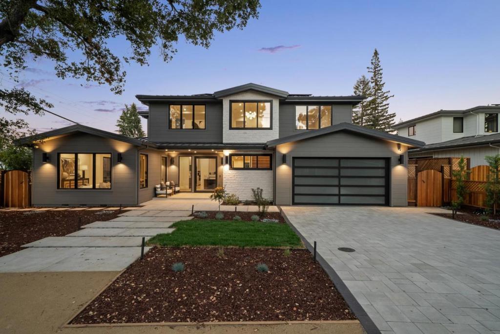 Set on a prime corner in a sought-after North Los Altos neighborhood, this newly completed home offers stunning modern design, luxurious functionality, and outstanding flexibility for a variety of lifestyle needs. The all-electric, solar-powered construction blends sleek architectural lines with warm finishes including Jerusalem limestone, wide-plank engineered oak floors, and custom cabinetry throughout. The versatile floor plan includes an attached 1-bedroom, 1-bath ADU with its own living area and kitchen, ideal for guests, extended family, or the living area can optionally be used as part of the main home. At the heart of the floor plan is an expansive great room with a dramatic linear fireplace, stacking sliding glass doors to the terrace, and a designer kitchen finished in striking quartzite. A main-level bedroom suite opens to the yard, while the upper level offers three more bedrooms, including a private primary suite with soaring ceiling and spa-inspired bath. Indoor/outdoor living is fully embraced with a heated covered terrace, a built-in barbecue center, and expansive lawn. Additional amenities include a 10 kW solar array, EV outlets in the garage, and premium windows and doors throughout. All of this, just one mile from the Village with top-rated Los Altos schools.