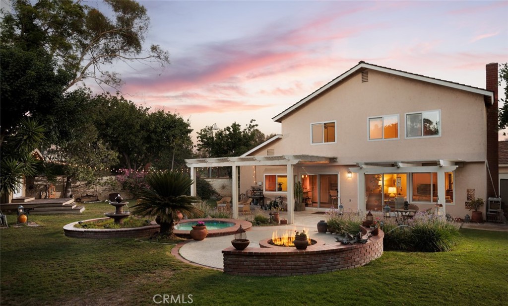 MABURY RANCH CHARMER | PRIVATE BACKYARD RETREAT | CORNER LOT ON SINGLE-LOADED STREET | UPDATED INTERIOR FINISHES | Welcome to 6049 E Mabury Avenue, a beautifully cared-for two-story home tucked into the highly sought-after Mabury Ranch community of Orange. Known for its wide, tree-lined streets, community events, and peaceful atmosphere, Mabury Ranch continues to be one of North Orange County’s most desirable places to call home, and this property is your perfect opportunity to join it. With charming curb appeal and a warm, welcoming interior, this 4-bedroom, 3-bathroom home offers a beautiful living space with tasteful updates throughout. Upon entry, you're greeted by vaulted ceilings and a light-filled living room that seamlessly flows into a formal dining space. Wide-plank flooring, neutral paint tones, and updated lighting provide a fresh, move-in-ready feel while still allowing space for your personal touch. At the heart of the home sits a spacious kitchen with granite countertops, bar seating, and a view out to the backyard. It opens to a cozy family room with a stone fireplace and built-in cabinetry, ideal for relaxed evenings or casual entertaining. Just off the family room, sliding doors lead to a stunning backyard oasis. With a large covered patio, in-ground spa, firepit, and gardens framed by mature trees and landscaping, the outdoor space offers privacy, comfort, and flexibility for year-round enjoyment. Tucked away in the back corner of the yard is a charming detached studio with French doors, skylights, and natural wood finishes. Whether used for painting, yoga, crafting, or quiet work-from-home space, this special retreat adds a layer of function and creativity few properties offer. Upstairs, the oversized primary suite features serene hill views, a large closets, and a beautifully remodeled en-suite bath with a walk-in shower and granite-topped vanity. Three additional bedrooms and a full hallway bathroom complete the upper level, offering plenty of room for family, guests, or a home office. Additional highlights include a 3-car garage, newer flooring, recessed lighting, and central HVAC. Residents of Mabury Ranch enjoy access to nearby walking trails, parks, and top-rated schools. Neighborhood events and activities include Hot August Nights Classic Car Show, holiday festivities, and nearby Santiago Oaks Park. Don’t miss your chance to live in one of Orange’s most beloved communities. 6049 E Mabury Ave is ready to welcome you home.