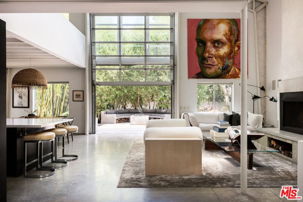 On a hushed Mar Vista block, this nearly 4,000-square-foot loft-inspired residence pairs dramatic volume with easy Westside living. A soaring two-story great room anchors the home, framed by a fireplace and an industrial glass facade that lifts open to the garden patio so everyday life spills outdoors. The open kitchen and dining zonecrafted with custom cabinetry, a stone prep island, and thoughtful detailskeeps cooking and entertaining effortless. Two secondary bedrooms plus a full bath and powder serve the main level. Upstairs, the private primary level feels like a retreat, offering a spa-style bath, generous walk-in closet, and an airy mezzanine perfect for an office or reading perch. The lower level adds a true cinema room for screenings or game nights. Out back, a freestanding studio with its own bath flexes for guests, creative work, or a gym. Mature landscaping, a tranquil water element, and a secure two-car garage round out the setting for a perfect 6 month lease. Close to neighborhood cafes and the coast, this home delivers light, scale, and versatility in one standout Mar Vista offering.