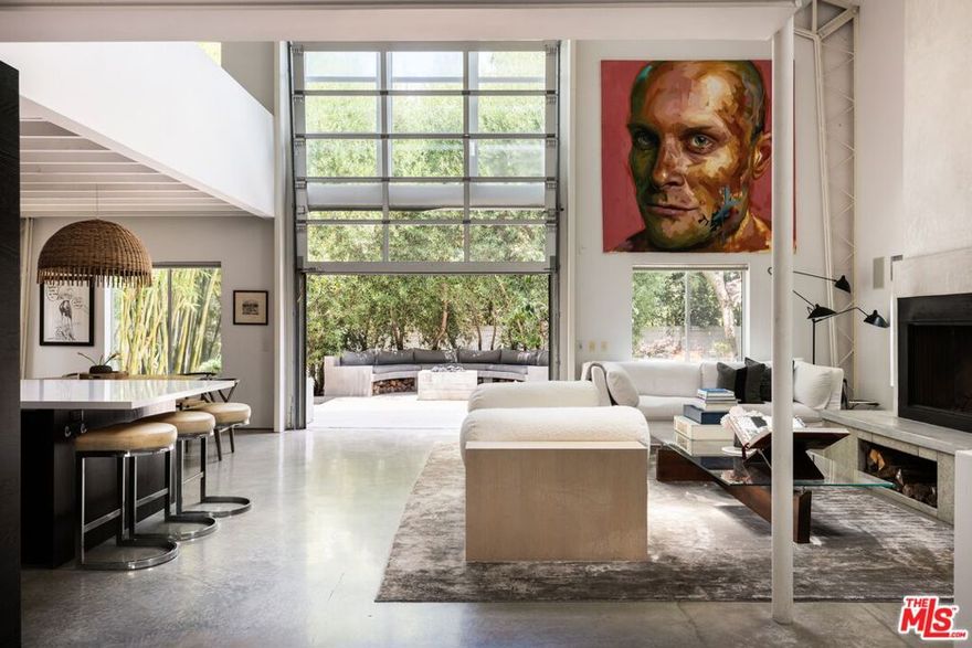 On a hushed Mar Vista block, this nearly 4,000-square-foot loft-inspired residence pairs dramatic volume with easy Westside living. A soaring two-story great room anchors the home, framed by a fireplace and an industrial glass facade that lifts open to the garden patio so everyday life spills outdoors. The open kitchen and dining zonecrafted with custom cabinetry, a stone prep island, and thoughtful detailskeeps cooking and entertaining effortless. Two secondary bedrooms plus a full bath and powder serve the main level. Upstairs, the private primary level feels like a retreat, offering a spa-style bath, generous walk-in closet, and an airy mezzanine perfect for an office or reading perch. The lower level adds a true cinema room for screenings or game nights. Out back, a freestanding studio with its own bath flexes for guests, creative work, or a gym. Mature landscaping, a tranquil water element, and a secure two-car garage round out the setting for a perfect 6 month lease. Close to neighborhood cafes and the coast, this home delivers light, scale, and versatility in one standout Mar Vista offering.