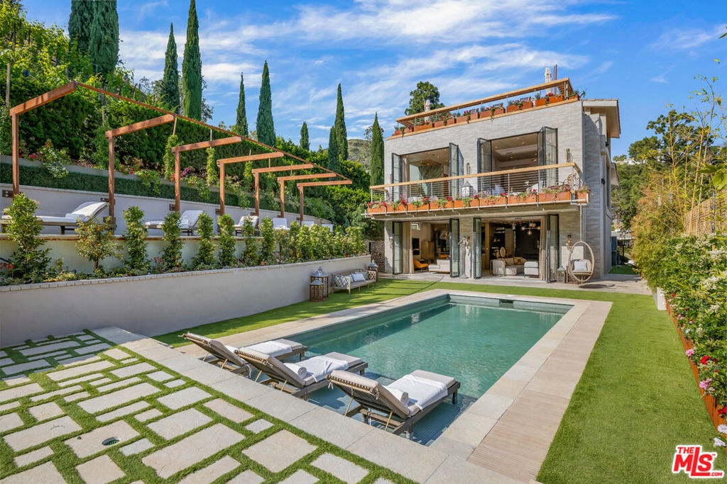 Welcome to Villa Montalcino. A slice of Tuscany awaits in the heart of the prestigious Pacific Palisades. A vision of elegance and charm, the estate was built in perfect harmony with its surroundings, where canyon serenity meets lush vineyards under a blanket of fresh ocean air. The newly completed Villa Montalcino is the latest in the lineage of architectural masterpieces by the renowned Arya Group. Nestled at the base of the Arya Estates Vineyard, this hillside haven is the only of its kind in Los Angeles, and transports you to a time and place that is uniquely its own. The perfect blend of warm modern luxury and comfortable functionality, the home boasts 4 beds & 6 baths, each offering its own glimpse of breathtaking canyon scenery. Tucked away in peaceful privacy, Villa Montalcino is only minutes from local beaches and the bustling Palisades Village. The sweeping open floor plan allows for a graceful flow through the main level, which includes formal dining, a breakfast area, beautiful kitchen, elegant powder room and two living spaces perfect for relaxation and entertaining alike. Seamlessly transition to the outdoor oasis through disappearing walls of glass, creating a harmonious indoor-outdoor experience. California living at its finest, the sprawling backyard includes a large pool with Baja shelf, BBQ area and endless patio / grass spaces for al fresco dining & lounging.The primary suite is a true sanctuary, featuring a fireplace and private balcony through accordion doors allowing for natural light, expansive green vistas, and fresh air to flood the space. The spa-like en-suite bath offers a gorgeous stone soaker tub, glass shower with three shower heads, dual vanities, heated floors, and a boutique-worthy closet. For breathtaking views of the ocean, escape to the expansive teak rooftop deck, where you can relax and soak in the beauty of the surroundings, or host an unforgettable gathering under the stars. Additional luxury amenities include well-appointed guest suites, state of the art security systems, an upper level loft, wide plank oak floors, Sonos sound system, Lutron light system, iPort, a laundry space with two washer / dryer sets & built-ins, and so much more. Uplighting throughout the interior & exterior accentuate the architectural beauty while creating a captivating ambiance. From impeccable finishes to seamless indoor/outdoor living and breathtaking views, this property offers an experience like no other. Decades of vision and imagination come to life with elegance, comfort and sophistication at Villa Montalcino.