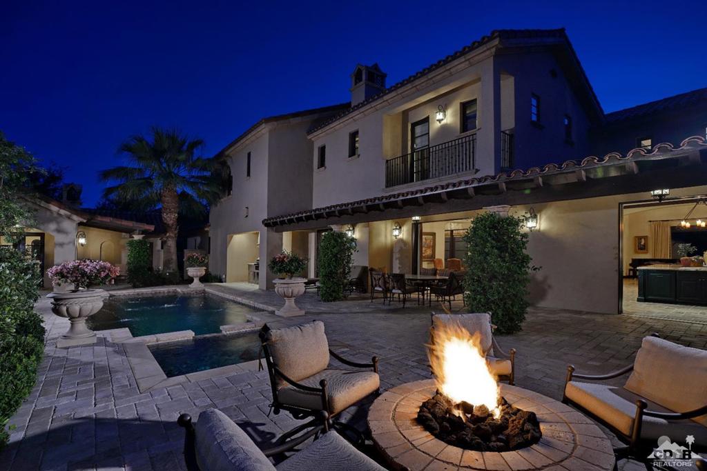 This highly sought-after 5-bedroom Villa behind the gates at The Madison Club, features elegant Spanish architecture throughout with soaring ceilings, rustic fixtures, grand staircase and warm fireplace. With 4,787 square feet of elegant living space, this home is the perfect luxury retreat. Enjoy time with family and friends in the open concept great room and kitchen with large center island. The primary suite offers warm ambiance with a cozy fireplace and over-sized soaking tub. There are 4 additional guest suites, including a detached casita, each with their own en-suite. You'll love the endless entertaining options as pocket doors open to a covered loggia, a sparkling pool and spa, fire pit for cool desert evenings and a full outdoor cook center. Offered furnished per inventory.