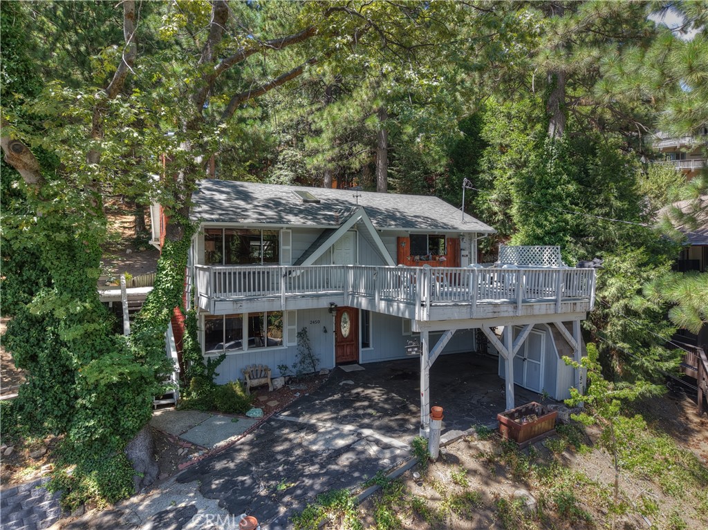 You will fall in love with this beloved family home in a great neighborhood! So many great memories were made here and now the time has come for a new family to make their own. Drive up the gentle driveway to the covered carport with room for multiple vehicles. There is a good size storage shed & level access into the lower level of the home. Once inside you will find a good size living area with a fireplace with a woodburning stove insert, 1/2 bath & large laundry/utility room. Upstairs you enter the main living area with T & G vaulted ceilings, warm wood walls & open concept living, dining kitchen area. There is another fireplace here as well. Main level also features 2 good size bedrooms & a full bathroom. Access from living room out to oversize waterproof deck area with gorgeous tree views & peeks of the valley below. From the kitchen area you can access the rear yard which offers lots of area for gardening, pets, etc & gives a nice feeling of space & privacy. There is also another deck space on the side of the house to enjoy the beautiful forest surroundings & views. This home does need a little refresh but the owner just installed new carpet throughout. The rest is easy! You even have a whole house automatic generator for all those pesky power outages! So much potential here in a wonderful location, just a quick hop to the town of Running Springs, 15 minutes to Highland at the bottom of the hill, & a short hop up to Snow Valley! An amazing location whether you are looking for full time or just a getaway & all on a maintained road. Don't let this opportunity pass you by!