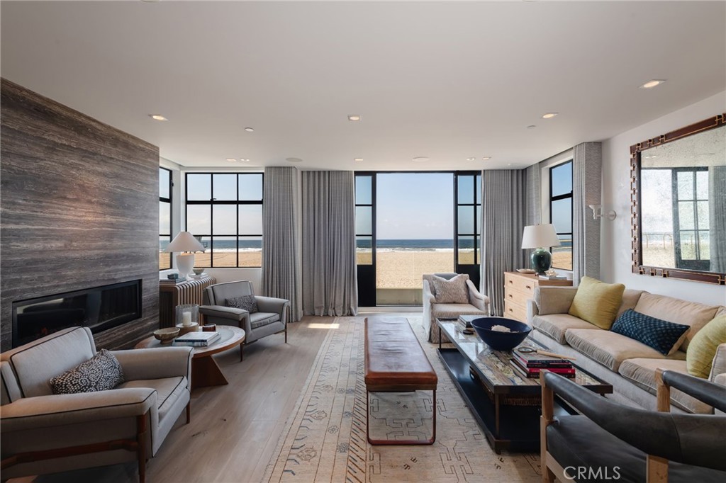 Introducing an exceptional oceanfront residence that redefines luxury beach living with unparalleled privacy on the North Hermosa Beach Strand. This turnkey luxury, furnished home, crafted by Matt Morris Development with designs by John Starr and Joe Lucas, offers a unique respite from the typical oceanfront property. The ultra-high-end furnishings complete this strikingly designed house, ready to welcome you with both style and comfort.
This is no ordinary Strand home. Every inch whispers elegance, from the hand-applied plaster walls and Waterworks plumbing fixtures to the dramatic steel-framed doorways and windows. It's a testament to craftsmanship, where timeless materials meet a meticulously curated design. The heart of the home features a stunning travertine fireplace and floor-to-ceiling windows that frame breathtaking ocean vistas, ensuring a picturesque backdrop from dawn to dusk.
Culinary enthusiasts will adore the gourmet kitchen, boasting bleached oak cabinetry complemented by a sophisticated grey-and-white herringbone backsplash. It’s an inviting hub of creativity and gathering, seamlessly blending elegance with functionality. For those who seek an indoor retreat that mirrors the tranquility of the beach, the beach room unfolds as a cozy haven featuring a pool table, stylish bar, and an expertly designed wine cellar. The beach room opens up to the sunken patio offering privacy from the Strand. Also, on this level, you will find the secluded office and a fun bunk room with walls clad with wood and brass ladders.
The primary suite, located on the third level, is the perfect space for rest and relaxation, with its own patio and stunning views. The other three ensuite bedrooms are on this level. Each room is decorated with a bolder flair, great style, and individual personality.
Entertaining is a breeze, especially on the rooftop deck equipped with a built-in barbecue, ice machine, refrigerator, and hot tub—ideal for enjoying serene sunsets. Perfectly situated on the north Hermosa Beach Strand, this residence invites you to live the quintessential coastal lifestyle. This home isn't just a place to live—it's a statement of living well. Come and see why it's not just another beachfront property; it's a beachfront sanctuary.