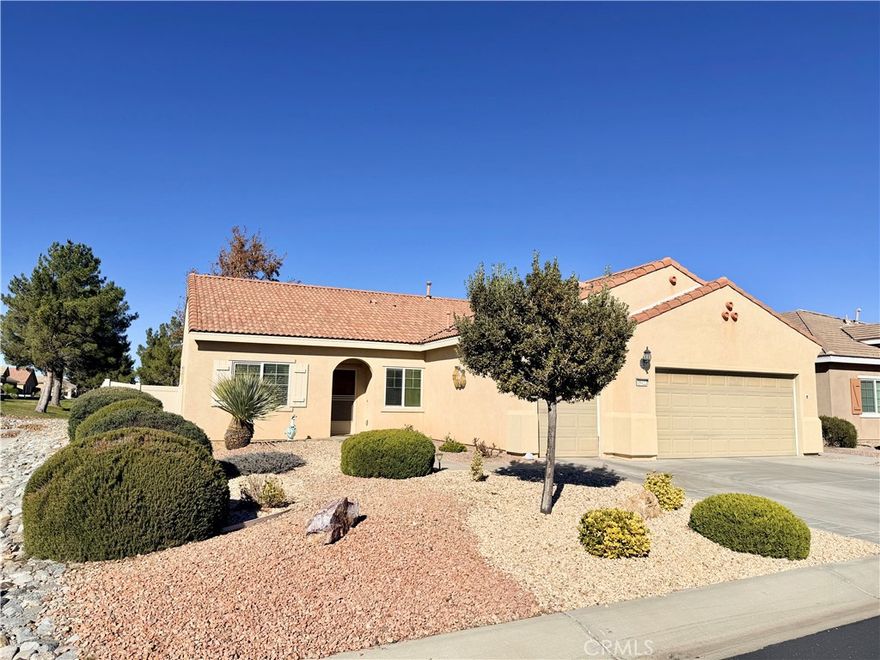 Introducing the Magnolia Model on the golf course in Solera at Del Webb, Apple Valley — a premier 55+ community. Perfectly positioned with a pond and fairway view, this beautiful home offers both tranquility and charm. Inside, you’ll find 3 spacious bedrooms, 2 full baths, a separate living room, and a dining room featuring a cozy fireplace. The open kitchen serves as the heart of the home, offering a seamless layout ideal for both everyday living and entertaining. The primary bedroom boasts its own private bathroom with dual sinks and an oversized walk-in closet, creating a comfortable and functional retreat. With low-maintenance desert landscaping in the front yard and a covered patio in the backyard, it’s the perfect setting for summer BBQs or relaxing evenings outdoors. Filled with wonderful features and truly move-in ready, this home is an absolute must-see.
Small-town charm blends seamlessly with wide-open spaces and panoramic views at Sun City Apple Valley. Nestled along the verdant fairways of Ashwood Golf Course and framed by a stunning mountain backdrop, this 55+ active adult community offers a truly serene setting. Enjoy intertwined bike paths and scenic walking trails throughout the neighborhood.
For golf enthusiasts, the 27-hole, par-65 Ashwood Golf Course is the perfect match. Stay active with two fully equipped fitness centers offering classes and full-time trainers, take a dip in any of the four sparkling pools, join one of the many resident clubs, or participate in a variety of team sports.