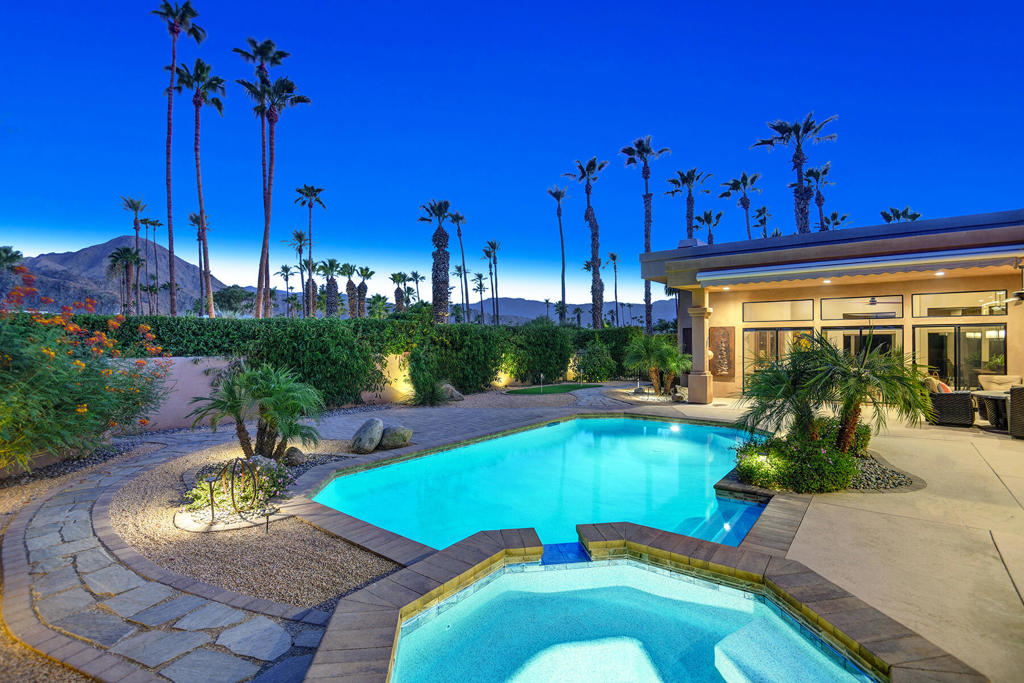 Perched on a premium, oversized 1/3rd acre corner lot affording exceptional privacy, this custom-built Desert Contemporary in the heart of Indian Wells boasts dramatic, unobstructed mountain views visible from numerous vantage points throughout the home. Designed for both elegance and comfort, the nearly 3,400 sq ft layout offers three spacious en-suite bedrooms, a versatile den/office currently used as a theater, and a powder room for guests. The open-concept design boasts soaring 12-ft ceilings and expansive walls of glass that flood the interiors with natural light while framing the awe-inspiring vistas. The remodeled chef's kitchen features quartz countertops, floor to ceiling sleek modern cabinetry, stainless steel appliances, and its own mountain backdrop. The great room, open to the dining area, centers around a striking, newly updated fireplace, while the primary suite provides a private, well-appointed retreat complete with an oversized closet and dressing area. Outdoors, your private south-facing retreat includes a pebble-finish pool and spa, putting green, dramatic landscape lighting and lush greenery with a covered patio and retractable awning - ideal for entertaining or serene relaxation against a breathtaking panorama. Practical luxury continues with a 2-car garage plus golf cart space, porte-cochere, and extra-long driveway secured behind a private gate. All just moments from the Tennis Gardens, world-class golf, fine dining, and boutique shopping and no HOA's. Enjoy exclusive Indian Wells resident discounts at resorts and IW Golf Club.
