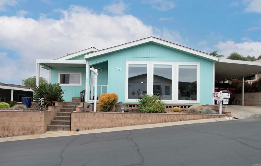 Foothills of San Marcos 55+ Land owned park. What a great place to call home! Seller will provide flooring allowance with acceptable offer.  Enjoy over 1500 SQ of living space. Spacious remodeled kitchen with recessed lighting, beige Corian countertops, and stainless appliances. Large living room with large picture windows to allow comforting light into the house. Good sized primary bedroom with a walk-in closet and recently remodeled ensuite bath. Newer bath includes newer double sink vanity, soaking tub, walk-in shower, newer toilet & newer flooring. Both baths have skylights. Indoor laundry room complete with utility sink. Newer water heater, a.c. unit and heater. Enjoy relaxing views and breezes from the front. Comfortable covered back patio. Nice backyard with artificial turf. So many amenities in this active park.  Community club house, tennis, swimming pool, card rooms, dog walking areas, and much more. Onsite RV parking for a fee. HOA includes cable with HBO & Showtime.