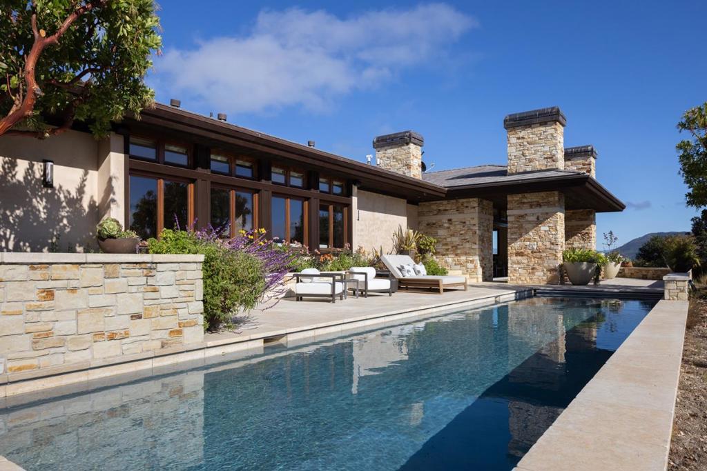 Set amongst the rolling hillsides of Clint Eastwood's world-renowned Tehama Golf Club, this exceptional 6,949 SqFt estate offers 5 bedrooms, 5.5 baths and premium craftsmanship throughout. Built in 2007, the home features San Ardo stone exterior, Jerusalem limestone floors, and rich wood accents. The chef's kitchen boasts custom Eggersmann cabinetry from Germany, while Italian Rimadesio closets and Konnen GlasHaus windows highlight bespoke design. Expansive living areas include 4 interior fireplaces, a media room with 4K projection, and seamless indoor and outdoor flow to terraces, fire pits, and 2 pools - a lap pool and cold plunge, plus a spa. Modern living includes enterprise-grade 1 gigabit internet and internet-enabled whole-house automation, including a Lutron lighting system, Yamaha MusicCast audio, and Honeywell security with Nest cameras. Energy efficiency shines with a full solar array, 3 Tesla Powerwalls, and advanced water systems. With a detached 3-car garage, radiant heating, guest house renovations, outdoor entertaining spaces, and a plumbed Ooni pizza oven, this property blends elegance, technology, and comfort in one extraordinary residence. Just minutes to world-class beaches, shopping, and restaurants, this is an incredible opportunity for Carmel luxury living.