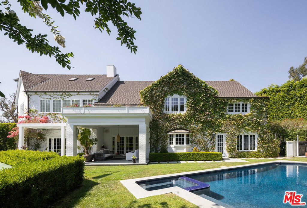 Located in the illustrious guard-gated Hidden Valley Estates, amidst the residences of Hollywood's celebrity elite, this traditional Colonial Revival estate has been passionately remodeled, blending classic timelessness with modern amenities and sophisticated upgrades. The interiors have been intentionally designed with meticulous craftsmanship and attention to detail. Imported stone, rich woodwork, and modern lighting create a peaceful sanctuary among the Hills. The designer kitchen is a chef's dream of burnished brass and green forest marble, with an elegant Officine Gullo cooking range as the centerpiece. Step inside the formal living room, where a stone fireplace, coffered wood ceilings, and custom steel and glass accents create a moody atmosphere. The family room and informal dining room flow into the outdoor spaces with glass doors opening up to a sparkling pool and spa, al fresco dining area, championship tennis court, and grassy lawn. Upstairs, the expansive primary suite is a tranquil haven with cozy fireplace, lounge area, marble bathroom with soaking tub and shower, and incredible double closet with dressing room. Two additional bedrooms are located upstairs along with a gym suite on the third floor. Downstairs, two suites including a media room and a guest room with separate entry making it perfect for guests or staff. Additional amenities include a dedicated lounge and seating areas, and direct access to Franklin Canyon hiking trails.