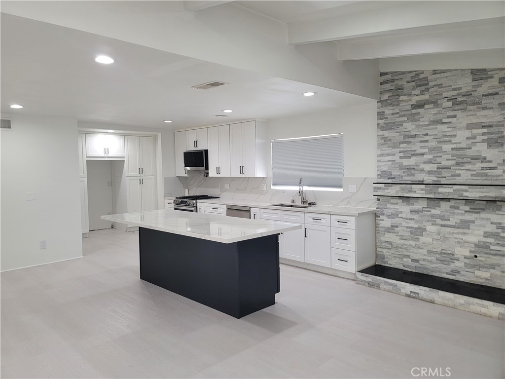 This beautiful home is nestled at the end of a quiet, tree-lined cul-de-sac in a desirable Sylmar neighborhood. It features an open floor plan and has been completely remodeled from top to bottom, including fresh exterior and interior paint. Enjoy laminate flooring throughout the living room, family room, and all bedrooms, with tile floors in the kitchen and dining area. The remodeled kitchen offers white-accented cabinetry, stone countertops, and a stylish tile backsplash. A beautiful marble-accented, wood-burning fireplace adds charm to the living space. The bathrooms have been tastefully updated with tile floors, tiled enclosures, and modern fixtures. Additional highlights include central air and heat, water-saving landscaping in the front and back yards. Conveniently located near an award-winning elementary school, shopping centers, and major transportation routes.