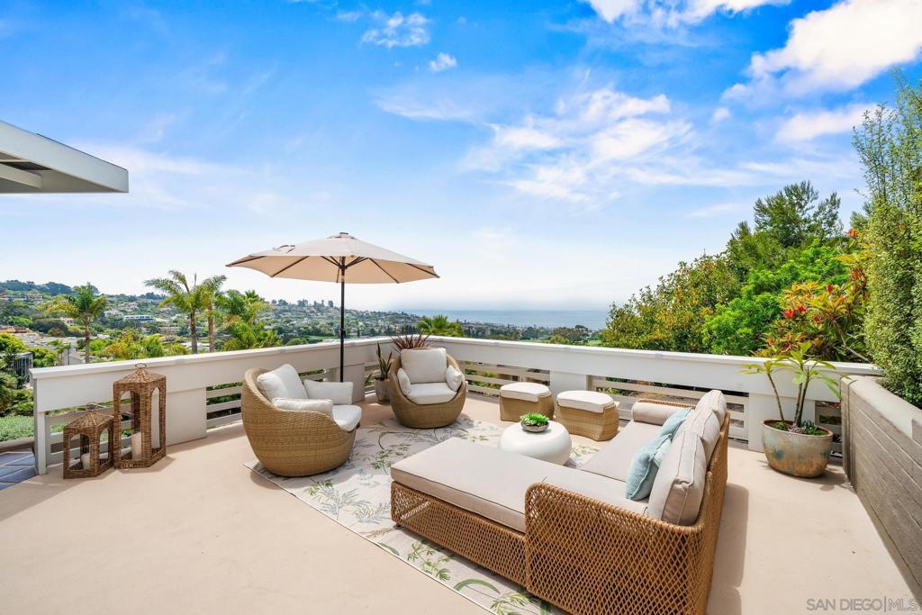 Perched above La Jolla Village, this elegant hilltop home offers panoramic ocean views, timeless architecture, and inviting spaces for a refined coastal escape. With multiple patios, a private spa, a firepit, and an upper deck overlooking the Pacific, it’s a rare retreat in one of San Diego’s most coveted neighborhoods. The main level features an ocean-facing living room with fireplace and large windows, a formal dining room with sweeping views, and a sunlit kitchen with breakfast nook and laundry room. Two king bedrooms are located on this level, each with an ensuite bathroom. The primary includes a walk-in closet and a spa-style soaking tub. The backyard is beautifully landscaped with a jacuzzi, dining table under string lights, and a grassy side yard ideal for outdoor games or relaxing in the sunshine. An upper deck just above offers unobstructed views over La Jolla and the coastline, with lounge seating and an outdoor dining area. Downstairs, a family game room includes a smart TV, foosball table, and queen sleeper sofa, plus access to a private firepit patio. Two queen bedrooms are also on this level—one with a walk-in closet, the other with backyard views—and share a full bathroom. Sleeping Accommodations (Maximum Occupancy 10): Bedroom 1 - 1 King bed Bedroom 2 - 1 King bed Bedroom 3 - 1 Queen bed Bedroom 4 - 1 Queen bed Shared Living Space - 1 Queen Sofa bed There are a total of 3 bathrooms STR-11600L TOT-659247
