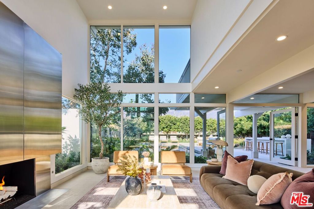 Behind the heavily guarded gates of the prestigious Malibu Colony stands this reimagined post and beam mid-century modern home, originally designed by renowned architects Buff and Hensman; the iconic duo, whose residences epitomized casual California living in the 1960's, seamlessly blending wood and glass structures that gracefully connect with their natural surroundings. Award-Winning Architectural Designer Warren Garrett dramatically enhanced this notable home while preserving its original integrity and design intent. Mature sycamore trees frame the secluded, contemporary mid-century dwelling as a sandblasted and brushed limestone walkway mimics the organic texture of the nearby beachfront. An open-concept floor plan throughout this 5 bedroom and 5 bathroom home boasts voluminous ceilings upon entering which lead to a floating staircase clad with wide-plank, white oak flooring enclosed by a wall of glass effortlessly joining the living spaces together and flooding the home with natural light. The gourmet chef's kitchen features all Gaggenau appliances, sleek cabinetry, and a spacious island. The home is automated with Universal Control4 access and equipped with an interior and exterior sound system. The primary bedroom suite presents a calm refuge upon entry. The spa-like bathroom includes limestone and white oak accents, a hand-worked rigato bathing niche, private WC and spa-like shower, all being flanked by two custom closets. A private balcony beckons you to soak in the California sun and admire the mountain and ocean views. The outdoor retreat serves as a natural extension of the living quarters where a glistening pool takes center stage. An inviting outdoor kitchen, with state-of-the-art appliances and ample seating, offers the perfect opportunity for al fresco dining under the stars becoming a destination for relaxation and entertainment. This stunning property is gated from the street with a large private courtyard spanning approximately 50 feet of street frontage. This home truly offers the best of the Malibu Colony with 24 hour security and a level of privacy that does not exist on the beach side. One can escape to the privacy of this estate while still being only steps away from their deeded beach access which is a beautifully landscaped and furnished beachfront experience exclusively for the use of a limited amount of homeowners.