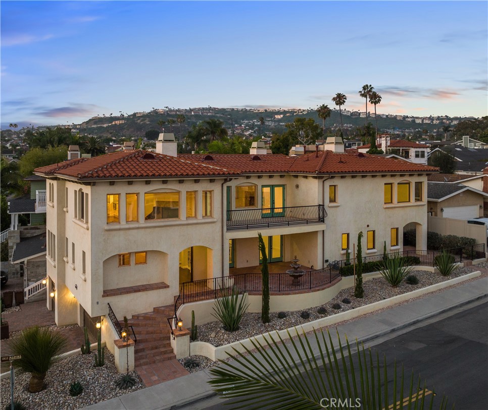 Welcome to your dream coastal retreat—this stunning lease opportunity is perched in one of Southwest San Clemente’s most sought-after neighborhoods, just a block from the beach. Perfectly positioned on a desirable SW-facing corner lot surrounded by charming homes and tree-lined streets, this immaculate residence captures the very best of San Clemente living with daily sunsets that inspire. Step inside and be immediately captivated by sweeping, unobstructed ocean views from the top-floor living spaces—views that stretch across the horizon and set the tone for true Southern California luxury. The upper level is designed to impress, showcasing a chef’s kitchen with Viking professional appliances, a granite island, a cozy breakfast nook, and an abundance of windows that feature breathtaking views and flood the space with invigorating natural light. The spacious second-floor primary suite is a true escape, complete with a stone fireplace, dual walk-in closets, and a spa-inspired bathroom finished in natural stone and tile. Downstairs, you'll find three additional ensuite bedrooms—and one that can be configured as a home office—offering both flexibility and comfort. Throughout the home, thoughtful architectural touches like arched doorways, wood-framed windows, designer lighting, and high-end finishes create a warm and sophisticated ambiance. Designed for both relaxation and entertaining, the property includes two outdoor patios: an enormous sunny ocean-view deck upstairs, perfect for sipping morning coffee or evening wine, and a tiled, covered patio downstairs, ideal for shaded lounging or al fresco dining. Additional features include a pristine three-car garage, ample driveway parking, built-in audio/video wiring, and fresh, light color throughout. Just minutes to San Clemente’s world-class beaches, hiking trails, and vibrant downtown filled with boutiques, cafes, and restaurants, this home is the perfect blend of luxury, location, and lifestyle. Don’t miss your chance to live in one of the most special homes in Southwest San Clemente.