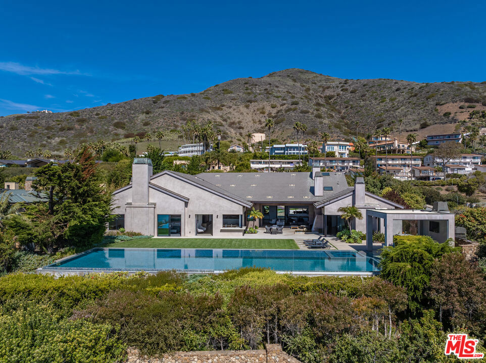 Nestled in the exclusive Marisol community of Malibu, 11902 Ellice St offers unparalleled oceanfront living. This large estate spans 10,532 square feet, including 5 bedrooms, 5 full baths, and 2 half baths. Set on a 1-acre bluff-top lot with 111 feet of oceanfront, this property offers breathtaking panoramic views you have to see for yourself. The home features high ceilings, French oak floors, and Italian marble finishes throughout. The open-concept living area seamlessly flows to outdoor spaces, while the gourmet kitchen and spacious family/media room provide luxury and comfort. The sun-drenched owner's suite features a fireplace, marble bath, and walk-in closet, with an additional suite offering a peaceful retreat. Outside, the resort-style grounds include a 75 ft infinity pool, spa, gazebo, and multiple fireplaces for ultimate relaxation and entertainment. With ample parking and a 3-car garage, this exceptional property represents the pinnacle of Malibu luxury living.