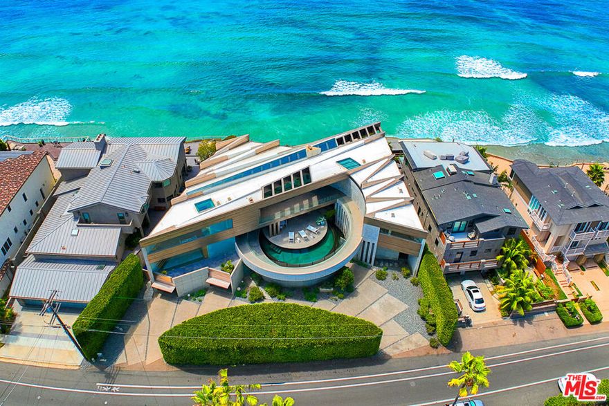 Perched on a 74-foot promontory with explosive panoramic ocean views, Crescent House is a one-of-a-kind architectural masterpiece. This unique, trophy property was created by three-time Architectural Digest Top 100 designer and visionary, Wallace E. Cunningham. Prominently featured in Architectural Digest Magazine and in the Season 3 premiere episode of HBO's Westworld, this property exemplifies a work of art. Sprawling over a double oceanfront lot and showcasing over ~6,300sf of interior space with modern concrete, titanium, and floor to ceiling glass windows that bring the outdoor ocean view in throughout its entirety. A tiered design and curved walls shield an alluring central courtyard with an entrancing crescent shaped infinity pool. The main home hosts an alluring living space with gourmet chef's kitchen, expansive primary bedroom with endless ocean views and spa-like bathroom. Accompanying the main home are two additional bedrooms, all with panoramic ocean views and bonus areas that could be used as a fifth bedroom, gym, yoga studio, media room, office, etc. Guest quarters offer an additional En-suite bedroom with a second room for a multitude of uses. Patios, verandas, terraces and decks throughout maximize the outdoor coastal living and gives an unmatched feeling of floating on the Ocean. With ocean views by day and city views by night, this home offers incredible spectacular vistas. This unrivaled property is more than just a home, creating an ideal combination of the ultimate luxury living with impeccable quality and paramount location, making it a true work of art.