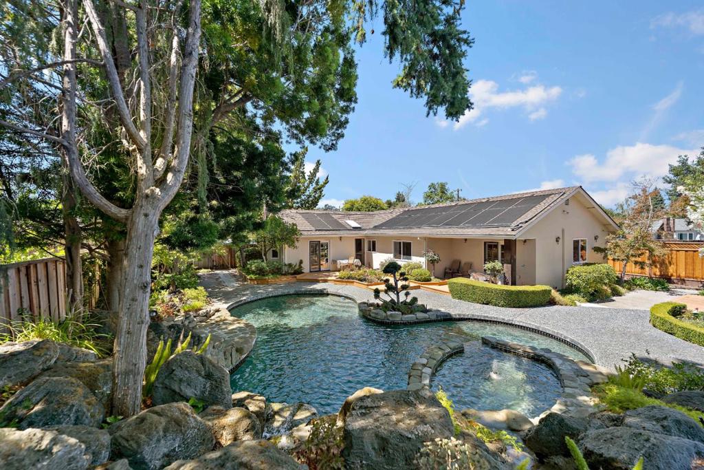 Welcome to this exceptional single-story home in a coveted neighborhood of Los Altos, where tranquility meets comfort on a quiet street near convenient amenities. This 2,319 square foot retreat offers 3 sizable bedrooms, 2 bathrooms, plus a thoughtful den, and attached office equipped with its own private heating and cooling system. The premium 11,152 square foot lot creates a private oasis that feels worlds away from everyday hustle. Chefs kitchen features an elegant granite countertop with plenty of workspace and ample cabinet storage. Step outside to discover your own backyard fantasy featuring a stunning resort-style pool surrounded by lagoon-inspired landscaping that transforms ordinary evenings into serene escapes. Inside, enjoy the luxury of central air conditioning, high vaulted ceilings, a primary suite with a generous walk-in closet, and seamless indoor-outdoor living flow. The spacious garage provides ample storage while additional office space adapts to your work-from-home needs. This rare gem hasn't been available since 1990, offering excellent schools including Springer Elementary, Georgina P Blach Middle, Los Altos High, and Saint Francis nearby. Moments from Rancho Shopping Center, beautiful parks, and major tech companies.