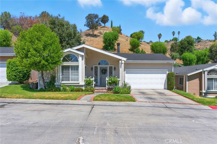 Welcome to this thoughtfully upgraded land lease home located in the desirable Canyon View Estates, a secure guard-gated community offering comfort, style, and convenience. After the foyer, step into a spacious great room featuring fireplace, high ceilings, new laminate flooring throughout, and a sliding glass door leading to the serene backyard. The open-concept layout flows seamlessly into the modern kitchen, boasting granite countertops, subway tile backsplash, stainless steel appliances, and a center island—perfect for gathering and entertaining. Enjoy your morning coffee in the cozy breakfast nook, overlooking the landscaped front yard. The primary suite is generously sized and offers custom automatic blackout shades, closet organizers, and direct access to the backyard. The remodeled en-suite bathroom showcases dual floating sinks, a soaking tub, and a spa-style shower with a sleek barn door. Two additional bedrooms also feature new laminate flooring, with one including built-in closet organizers. The second full bath has been tastefully remodeled to match the home’s cozy modern look. Step outside to your private backyard oasis, complete with ample shade, spa, plenty of grassy space, and mountain view backdrop—ideal for relaxing or entertaining. Additional upgrade include: new garage door opener, new security front door, new ceiling fans, and new lighting. Community amenities are 24 hour gated access, 2 pools and spa, 2 sports courts, 2 play areas, clubhouse, and RV storage. Conveniently located near bike and walking paths, close to parks, shopping, schools, and entertainment.