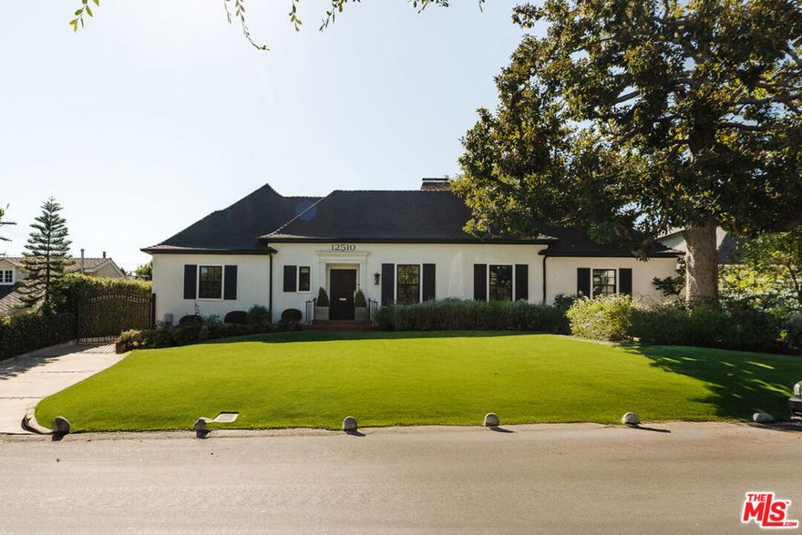 This exceptional single-story residence blends timeless traditional architecture with modern sophistication in a sought-after neighborhood just moments from Beeman Park. With enviable curb appeal, manicured landscaping, and a stately presence that commands attention, this home radiates classic charm and enduring elegance. Inside, refined woodworking and impeccable architectural details abound, including dental crown molding, fluted columns, wainscoting, and graceful archways. Lustrous real wood floors flow throughout, enhancing the home's warmth and sophistication. The gracious formal living room features high ceilings, serene garden views, and a classic wood-burning fireplace. The elegant formal dining room is ideal for hosting memorable gatherings, while the adjoining breakfast room offers a bright and cheerful setting for casual dining or a convenient workspace. The completely remodeled kitchen combines state-of-the-art design with beautiful tile work and premium finishes, creating a space that's both functional and inspiring. The oversized family room, anchored by another fireplace, opens through sliding French doors to the crown jewel of the home  a spectacular covered porch with ceiling heaters, fans, twinkling caf lights, and an outdoor BBQ. Perfect for entertaining, this inviting space overlooks the newly renovated pool and spa and a lush, low-maintenance lawn. The home features four bedrooms, with the fourth currently serving as a custom office or children's playroom, complete with built-in cabinetry and desks. Two secondary bedrooms boast generous walk-in closets and share a beautifully remodeled bath with elegant tile and a soaking tub. The primary suite offers a peaceful retreat with dual walk-in closets, a romantic chandelier, and a stunning spa-inspired bath featuring a Signature Hardware tub and Rohl fixtures. Sliding French doors open directly to the back patio and lawn, creating a seamless indoor-outdoor connection that invites relaxation, morning coffee al fresco, or quiet evenings beneath the trees. Outdoors, mature trees provide beauty and shade. The detached oversized two-car garage offers ample parking and storage. A separate detached gym, tucked beside the pool, is ideal for morning or evening workouts followed by a refreshing swim. Located in the heart of Studio City, this remarkable home offers easy access to the area's best shops, restaurants, parks, and schools  blending elegance, comfort, and classic California indoor-outdoor living in one of the Valley's most desirable neighborhoods