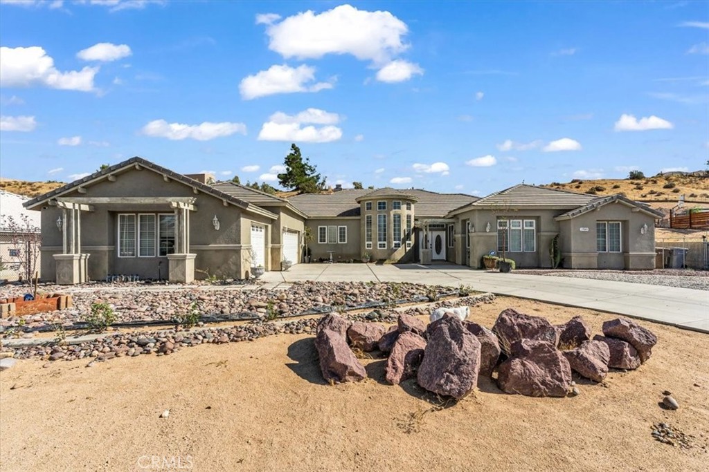 This stunning, custom-built estate offers 3,438 square feet of living space on a huge 37,000 sq. ft. (Approx) lot is designed for versatility and upscale living. The flexible floor plan is a dream for multi-generational living, featuring two complete primary bedroom suites with private en-suite baths. Entertain effortlessly in the spacious formal dining room or gather around one of two cozy fireplaces that anchor the light-filled family room. With a massive driveway for guest parking, entertaining will be a new norm. Blessed with a 3-car garage and an enormous backyard, options for expansion or income generation is available. Situated in a mature, sought-after neighborhood, this property delivers scale, style, and endless potential.