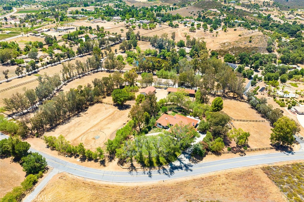 FANTASTIC HORSE RANCH – PRICED TO SELL! Single-story 3658 square-foot custom home with arena-ready pasture, round pen, extra pastures, cross-fencing, barn, private water well, workshop/garage with separate entrance, trail access…IN THE HEART OF LA CRESTA! This location is easy to access, with just a few turns from the Plateau entrance, and offers a plethora of mature trees, stunning views of the local mountains & neighboring ranches, and access to some of the Plateau’s best riding trails. It is fully fenced with multiple turn-outs, a graded pad ready for a 200’ x 65’ dressage arena and peppered with authentic artisan stone walls, viewing deck and steps. The charming single-level 5-Bedroom + Office ranch-style home sits above the equestrian areas, presenting a lovely opportunity to enjoy the La Cresta Life while viewing your ranch animals from multiple parts of the large grassy yard. It also offers a spectacular floorplan with the expansive vaulted-ceiling Primary Suite on one end, the three guest bedrooms on the other, a gorgeous living room with a wood-burning fireplace and wall of glass doors, separate dining room & family room with fireplace & wet bar, and a sweet breakfast room off the kitchen. The dedicated office has a private exterior door entrance & built-in cabinetry, and the entire home has a fresh coat of paint and new interior doors & casings with stylish hardware. The very new free-standing garage/workshop with 14-foot ceiling and two roll-up doors accommodates 4 cars, plus another space for tools and equipment, has its own driveway and a ton of open space around it. This adorable home with all the bells and whistles of a good working ranch is move-in ready and has it all! Just bring the family and critters! SELLERS ARE MOTIVATED TO SELL QUICKLY! DON’T DELAY! *****Discover the Santa Rosa Plateau Lifestyle…5-acre minimum parcels (10-acre minimum. in SR West), just minutes to schools, restaurants, hospitals, grocery stores, 15 Fwy & Temecula Wine Country. Enjoy this peaceful ranch community w/no commercial businesses, robust social activities, miles of private community trails & 1000s of acres of Ecological Reserve…All less than 1.5 hours from LA, SD, OC, Palm Springs & Big Bear. Discover the country, yet convenient, lifestyle of La Cresta, Tenaja & the Communities of the Santa Rosa Plateau!