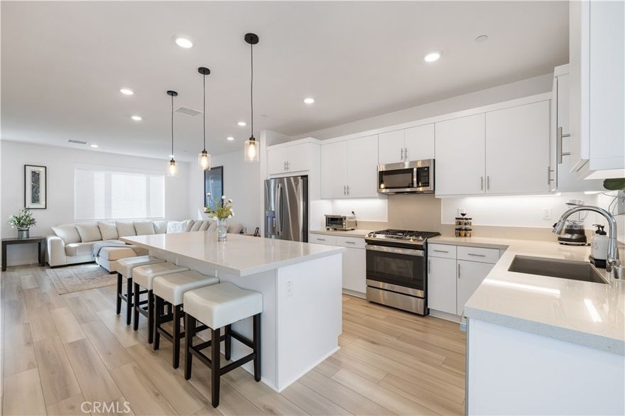 Popular Calla Plan 2 townhome located in the beautifully designed FivePoint Valencia community. This stylish 3 bedroom, 4 bath residence combines modern design with thoughtful functionality across three spacious levels.
The entry level welcomes you with a spacious foyer and a private ensuite bedroom with a large walk-in closet, perfect for flexible use such as a guest retreat or home office. The main living area features an open-concept layout filled with natural light, showcasing upgraded LVP flooring, a sleek kitchen with Quartz counters, Café appliances, and an expansive island ideal for entertaining or casual dining. The living and dining areas flow seamlessly to a private balcony, creating an easy indoor-outdoor lifestyle where you can enjoy fresh air and views. A convenient powder room completes this level.
The third level includes the spacious primary suite with large walk-in closet and a beautifully appointed ensuite bath, plus an additional bedroom with its own ensuite bath. The laundry room is conveniently located on this level for ease and function. Additional features include upgraded LVP flooring, upgraded carpeted upper level, tankless water heater, EV charging system, and smart home technology for energy efficiency.
Ideally located across from Verve Park, residents can enjoy open green space, modern playgrounds, outdoor fitness stations, and library. This thoughtfully planned community provides access to multiple scenic trails, bike paths, neighborhood electric vehicle routes, Eastlink Park, Confluence Park and community pools creating an exceptional outdoor lifestyle.