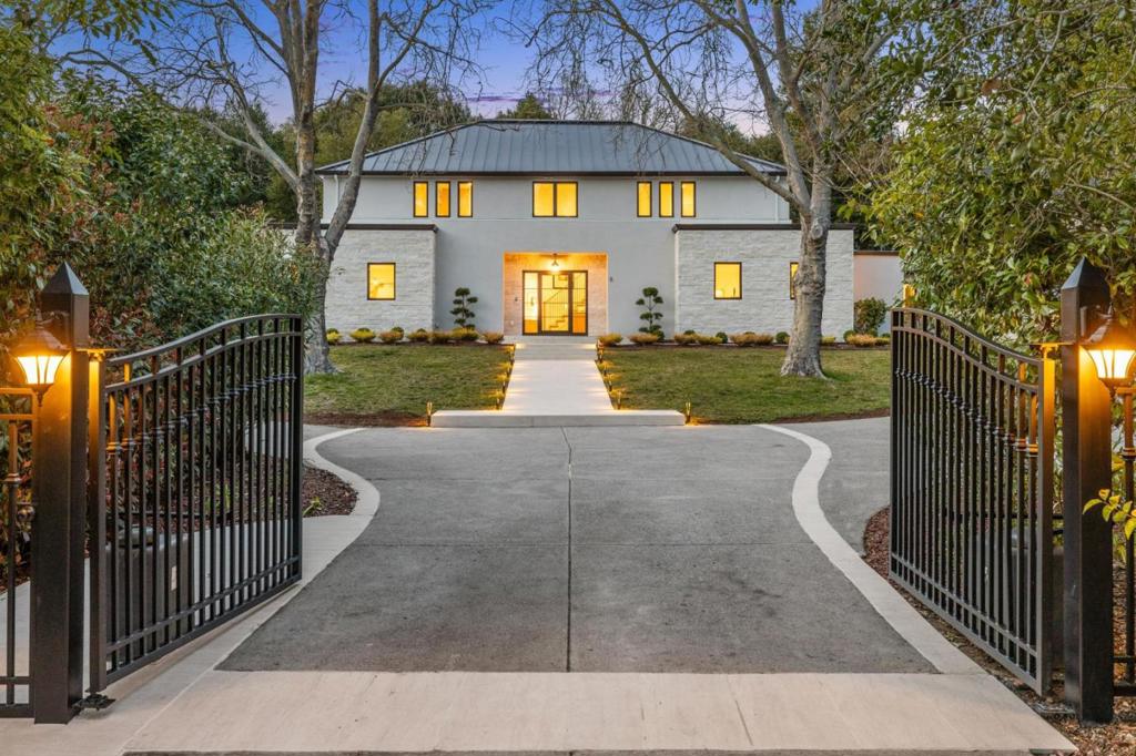 Discover unparalleled luxury in this spectacular modern estate offering 5,560 livable sq feet and ideally positioned atop a 2.5-acre knoll in the heart of Portola Valley. Expertly re-envisioned by Handa Developers Group, this residence offers sweeping western hill views, privacy & expansive flat grounds for seamless indoor-outdoor living. A gated motor court leads to a dramatic glass entryway opening to elegant living & dining spaces that frame picturesque vistas - ideal for intimate gatherings or grand entertaining. The heart of the home is an expansive kitchen-family great room featuring a large center island, Wolf & Sub-Zero appliances, a sleek wet bar & doors that extend effortlessly to the outdoors. The main home offers 6 beds & 4.5 baths, including a luxurious primary suite with a spa-inspired bath. A main-level guest suite & dedicated office add flexibility. Outdoors, resort amenities include a sparkling pool, a covered outdoor dining/kitchen pavilion, fully equipped guest house with bedroom, bath, full kitchen & laundry, plus a pool house with gym & full bath. The expansive flat turf lawn & putting green complete the idyllic grounds. Benefitting from Portola Valley schools & close to Stanford, Sand Hill Rd & top tech campuses, this is an exceptional Silicon Valley estate.