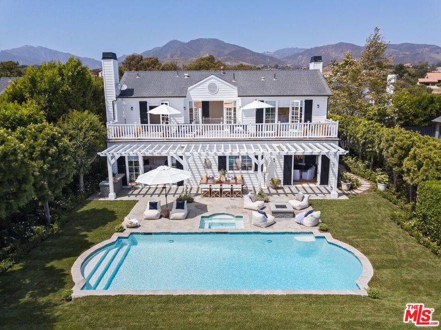 Elegant and impeccable, this traditional Cape Cod home sits at the end of cul-de-sac in a gated community on Point Dume with beach key access. The gourmet chefs kitchen has been designed and outfitted by Clive Christian. French doors seamlessly open the kitchen and living room to a trellis covered outdoor dining and sitting area. The professionally landscaped back yard is an entertainers dream with a large pool, rose gardens and built in bbq and fire pit. The interior features high beamed ceilings, hardwood floors, and windows and decks that overlook the manicured grounds. The interior rooms are categorized by a formal living room with fireplace, formal dining room, sun-filled family room with fireplace  gourmet kitchen with chandelier island, Calcutta marble countertops, breakfast/lunch dining area, and custom designed office/bedroom. Upstairs landings open onto full-width deck overlooking the gardens. There are three bedrooms all decorator designed with an owner's suite with a private deck and a spa style bath with custom closets and marble floors, plus two additional bedrooms. Detached is a two-car garage with built-in storage and guest parking.