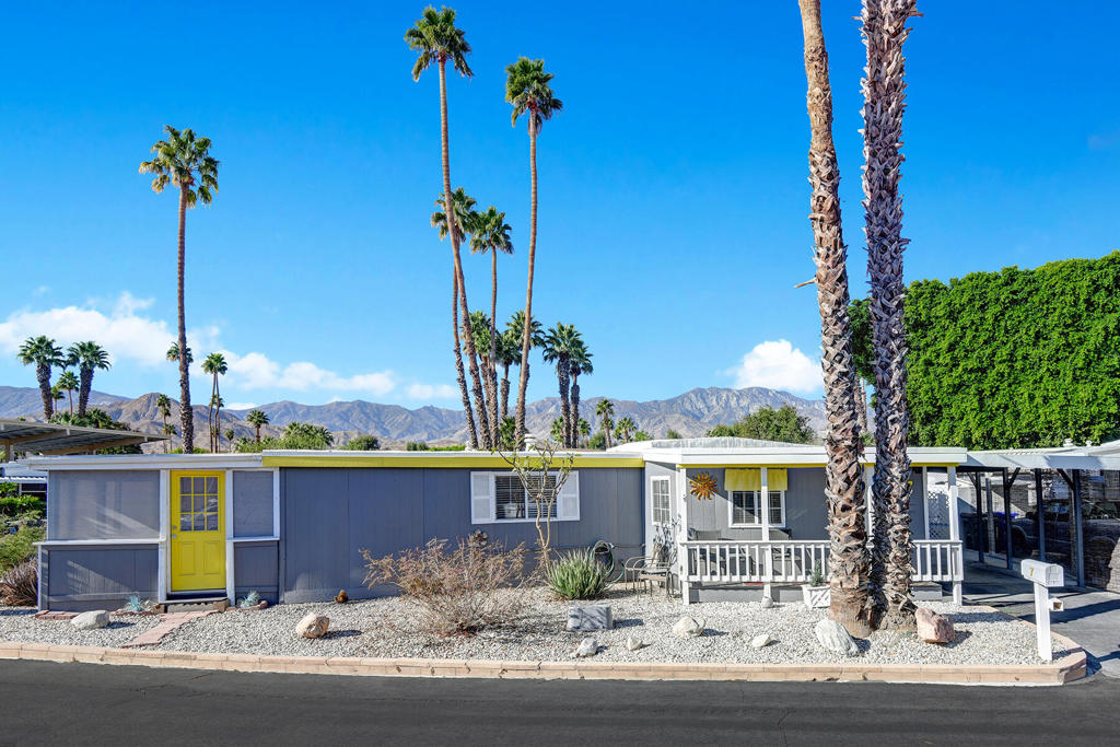 This beautifully remodeled home in the 55+ gated community of Royal Palms in Cathedral City is a unique property. Originally a mobile home, that has been completely transformed inside and out, offering approximately 1,135 sq. ft. of modern comfort and charm. Features include an open-concept living and dining area, a spacious kitchen with full-sized appliances and a bar-style counter, two bedrooms, a newly completed full bathroom, and an additional full bathroom with walk in shower. The home boasts updated vinyl-framed double-pane windows, laminated wood flooring, a central gas furnace with AC, and a mini-split AC unit in the dining room for extra cooling. Situated on a quiet corner lot near the back of the community, the property includes a covered front porch, an additional 185 Sq ft screened-in sunroom, a carport, and two large storage sheds. The Royal Palms community offers resort-style amenities, including a clubhouse, pool, hot tub, sauna, gym, pickleball and shuffleboard courts, and putting and chipping greens. Immaculate and ready to move in. Space rent $852/mo