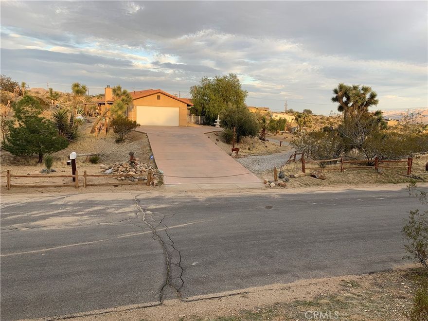 Discover a captivating city lights view from this 4-bedroom, 3-bath home nestled in a tranquil cul-de-sac freshly paved, boasting a wilderness panorama view. This private oasis, was built in 2004, spans .85 acres . The entrance is nothing short of dramatic, providing the perfect perch to savor both sunrises and sunsets. Featuring a tiled roof and cool tiled floors throughout, the home exudes a refreshing ambiance. The spacious kitchen offers a scenic backdrop, complete with double ovens. A fireplace graces the living room, while ceiling fans adorn every room. The dining room, with glass sliders leading to the rear yard, presents a dramatic view for your dining pleasure. The expansive master suite includes a generous walk-in closet and glass sliders, inviting in the cool morning and evening breeze. A second master suite, with its own full bath, also opens up to the rear yard through glass sliders. The oversized 2-car garage is impeccably finished with epoxy floors, complemented by a concrete driveway. A green house in the rear garden adds to the property's charm. With numerous amenities to offer, this one-of-a-kind residence is a rare find. Don't miss out on the unparalleled location and breathtaking views! Explore the captivating beauty of Joshua Tree National Park and indulge in a delightful shopping experience in the charming town of Yucca Valley. Immerse yourself in the stunning landscapes of Joshua Tree National Park, located in close proximity.