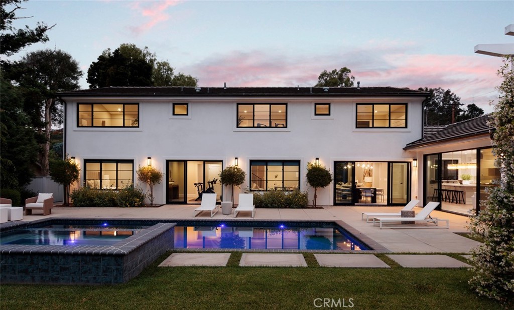 Newly rebuilt in late 2022 from the studs out and completely reimagined and expanded, this fabulous new home in Villa Park is truly unparalleled. Move-in ready, the residence offers the rare and enviable combination of newer construction in an established neighborhood, with mature landscaping and a prime corner homesite of about .46 acres adding to its undeniable appeal. Bathed in natural light that shines through an abundance of large windows, the open design showcases a foyer and living room with double-height ceilings, a contemporary staircase and a lofty interior balcony above. The grand dining room is certain to be a favorite place to share memorable occasions, and it opens to the backyard, creating a seamless indoor/outdoor vibe. Equally open and stylish, the on-trend kitchen displays white Shaker cabinetry, a large island with bar seating, quartz countertops, subway tile backsplash, a stainless steel pro-caliber range, and a built-in cabinet-matched refrigerator. The kitchen flows effortlessly to a family room that is distinguished by a high ceiling, backyard access, and a stone fireplace flanked by custom built-in shelving and cabinetry. Sophisticated and modern, the home’s aesthetic is embellished with warm white and gray hues, wood-plank flooring and chic LED lighting. Five bedrooms plus office/gym and four and a half baths are featured in approximately 4,005 square feet, including ensuite bedrooms, a main-level bedroom, an office, and an upscale-modern primary suite with a vaulted ceiling, freestanding tub, separate shower and two sinks. Grounds are impeccable, with low-water plantings, a tranquil pathway, and an attached three-car garage with a large paver-finished driveway in the front yard. The rear yard reveals a brand-new pool and spa, a large patio, verdant lawn, a lower level with fragrant orange trees, and a beautiful pavilion with a built-in BBQ bar. Excellent schools serving K-12 are nearby, and parks, shopping centers, trails, and restaurants are close to home.