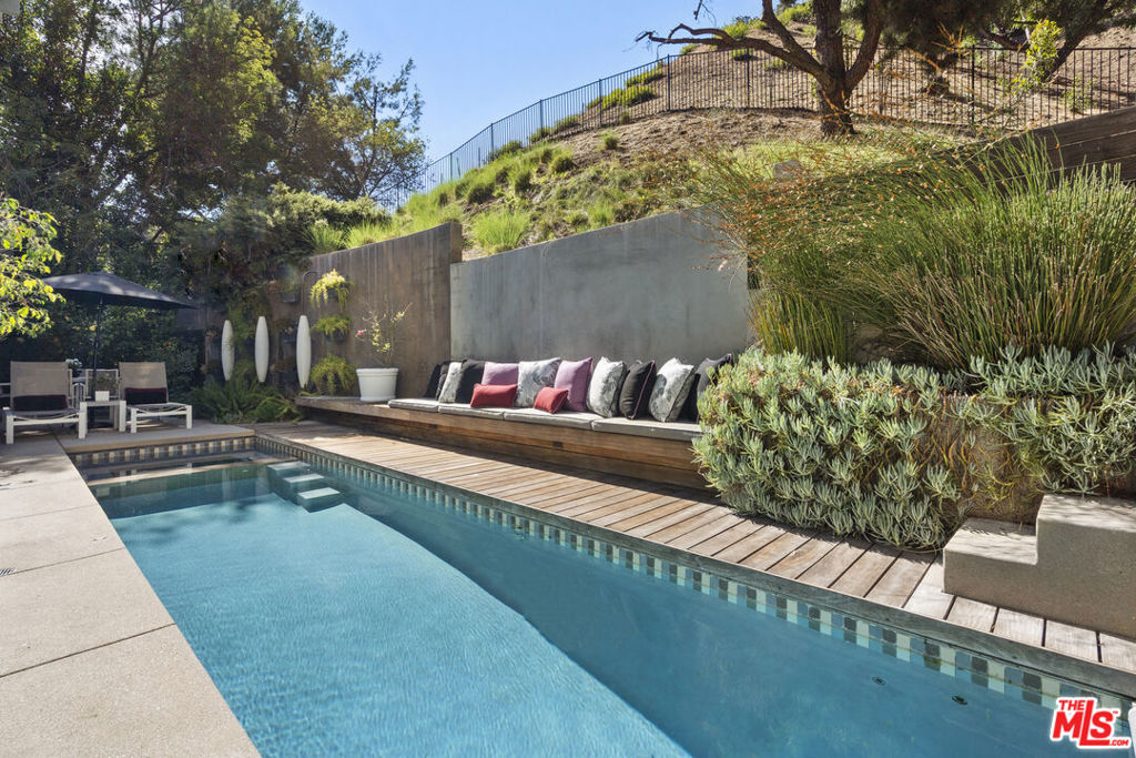 Escape the city right below to a Stunning Oasis~This is the Perfect Home ideally located on a peaceful and quiet cul-de-sac in Beverly Hills 90210 just below Beverly Park. This Warm Contemporary Ranch Home with a Dramatic Entry Courtyard with large grassy gated yard to your front door offers 4 bedrooms, 3.5 baths and has been tastefully remodeled inside and out with Gourmet kitchen with new white quartz counter tops, top of the line appliances including Sub Zero and Viking, center island, and family room, spacious living room with high ceilings and lots of windows making this home light and bright throughout. The Primary suite over looking the tranquil backyard and Pool area includes a wood burning fireplace, sitting area, walk-in closet, stunning bathroom with porcelain heated floors, a custom tub & large shower. All bedrooms are upstairs including the Primary and 3 guest bedrooms. This amazing home and property offers Avocado and fruit trees including lemon, lime, blood orange, and of course apricot. The back yard offers a professionally designed pool & spa with new equipment, romantic outdoor lighting and al fresco dinning, making it ideal for entertaining. 12 foot fencing and 12 camera ADT pulse security system indoor and outdoor add to the homes privacy and security throughout. There is a pristine powder coated 2 car attached garage with new garage door motor to show case your beautiful automobiles and storage space as well. This is truly an incredible home in a prime location with lots to offer the next Buyer(s) to enjoy the perfect life indeed! No Open Houses, please text listing agent for all showings.
