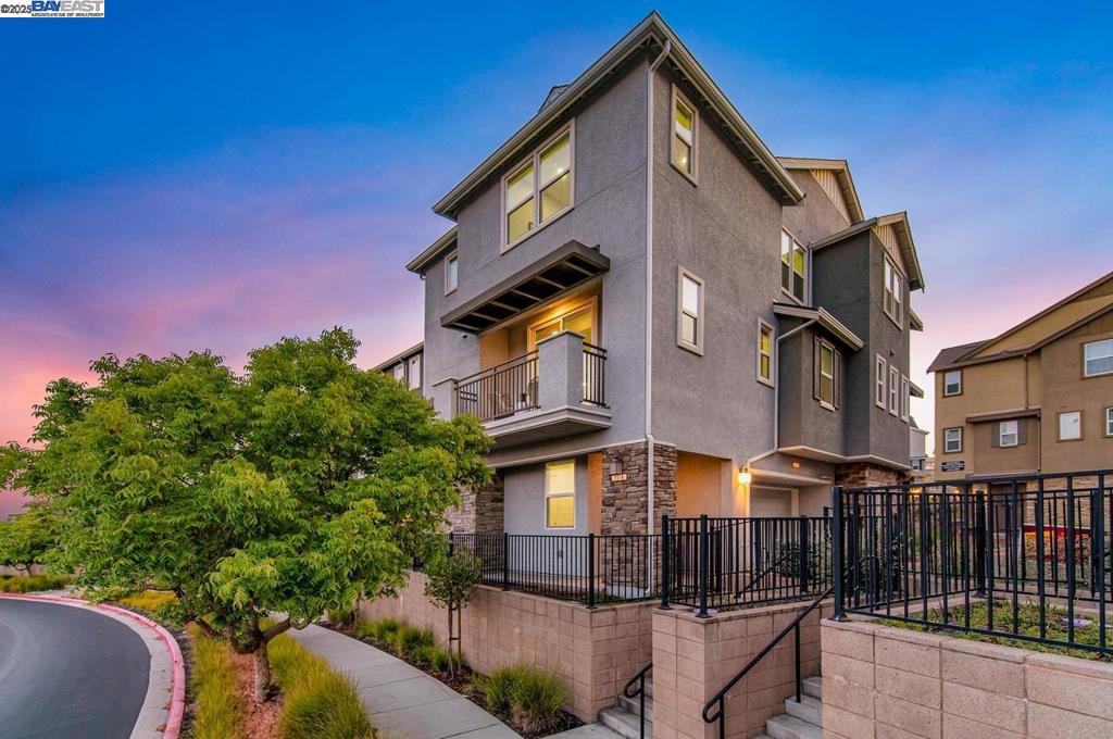 Welcome to beautifully upgraded north-facing 2-bedroom, 2.5-bath end-unit townhouse-style condo located in the prestigious gated community of Wallis Ranch. This light-filled home features an open-concept layout with custom accent walls, recessed lighting, upgraded tile and hardwood flooring, and a private balcony with peaceful views of preserved nature and rolling hills—perfect for relaxing or enjoying your morning coffee. The gourmet kitchen includes a large center island, quartz countertops, designer tile backsplash, modern shaker-style cabinets, and high-end stainless steel appliances. Ideal for entertaining and daily living. Both bedrooms are spacious en-suite primary suites with private bathrooms. The laundry room is conveniently located on the same floor. Attached side-by-side 2-car garage includes epoxy flooring, EV charging pre-wiring, a tankless water heater, and a water softener system. Enjoy resort-style amenities at The Kindred House with a pool, spa, 24-hour fitness center, clubhouse, and community events. Wallis Ranch also offers scenic walking trails, playgrounds, and beautifully maintained grounds. Easy access to freeways, BART, top-rated schools, shopping, and dining. A perfect blend of modern luxury and convenience—don’t miss this opportunity!