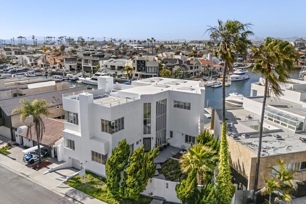 This extraordinary residence in Coronado Cays represents a unique opportunity to own a one-of-a-kind home with exceptional design and timeless luxury. Crafted to perfection, this home features a towering height of 33 feet, including breathtaking 18 to 21-foot ceilings that create an expansive, open atmosphere. Designed before recent building codes and HOA restrictions, it offers rare architectural elements that are no longer allowed, making it a truly irreplaceable property. The home’s subterranean garage with 10-foot ceilings provides ample space for several vehicles, ensuring plenty of room for your prized collection. Directly attached to the garage, an art storage room, wine cellar, and workshop give this home a creative edge that offers unparalleled functionality and style. An elevator connects all levels, providing ease and convenience throughout the expansive floor plan. Enjoy stunning views from every angle—whether it’s through the 14-foot windows of the living room that frame the natural beauty of Coronado or from the rooftop deck, which offers panoramic views of the surrounding area. From this vantage point, you'll be treated to spectacular firework displays during the annual Big Bay Boom, making every holiday season truly unforgettable. This magnificent property represents a rare blend of exceptional craftsmanship, luxurious living, and unparalleled views in one of Coronado's most coveted locations.
