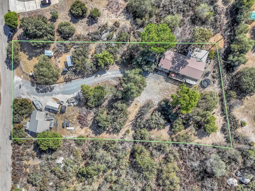 Are you looking for a beautiful piece of property located in a private location but very close to town? Look no further, as this magnificent 1.33 acre property with beautiful manzanita trees, boulders and a serene feel is waiting for you! The property also offers two horse corrals with a tack shed! Detached large shop with a one car garage! Hidden and tucked away off the private street of Lilac Ranch Rd. is a gorgeous 3 bedroom with a den (optional 4th bedroom), 2 full bathroom family home. Walk into this beauty and admire gorgeous wood flooring throughout most of the home. Enjoy a large living room and a separate dining area with beautiful newer carpet. A nice size kitchen that opens up to a family room - ideal for entertaining while cooking. Large Primary Bedroom located on opposite side of house that offers massive closet space and a private primary bathroom. The primary bathroom offers a large separate tub and shower. Down the hall is two more bedrooms and a den (optional 4th bedroom). The hallway bathroom has been updated with new fixtures. Large laundry room with sink and area to fold/hang clothes. Walk out the back door onto a covered patio area - great for barbecuing or entertaining. The front porch offers an area to relax and drink coffee while soaking in the tranquility and peace this beautiful property offers. Take in the magnificent sunset while relaxing on the porch. The shop/garage offers 700 square feet with fully powered 1000 watts of solar panels charging a 24 volt battery system. The batteries run the 4000 watt pure sine inverter. 8000 watt surge power system will run lights, garage door opener, tools, refrigerator, tv, etc. Plenty of room for a trailer, RV, boat & more! Close to shopping, schools & more!
