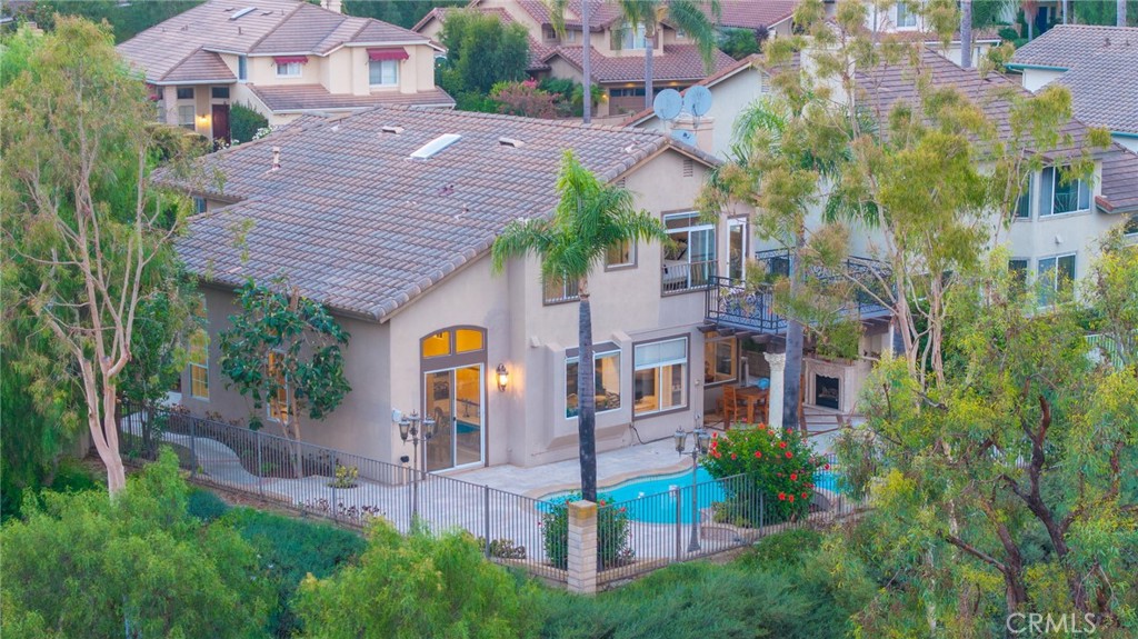Set on a premium 10,000+ sq ft lot, this beautifully maintained home offers stunning 180-degree views of mountains, hills, and twinkling city lights. With nearly 2,800 sq ft of living space, the home includes 4 bedrooms, 3 bathrooms, and a spacious bonus/media room. The grand entry features marble flooring with a granite medallion, leading to open living areas perfect for entertaining. The chef’s kitchen boasts granite countertops, a large center island, and stainless steel KitchenAid appliances—oven, cooktop, refrigerator, microwave, and trash compactor. The primary suite includes a private balcony to enjoy the view, while the ensuite bath showcases dual granite vanities, marble floors with insets, and elegant finishes. A main-floor bedroom provides flexible living options, and the secondary baths feature granite counters, marble floors, and full-height marble walls. Upgrades include custom woodwork, crown molding, a surround sound system, and stunning wrought iron details on the front doors, staircase, and accents throughout. The gated front yard features brickwork, roses, fruit trees, and vibrant landscaping. The 3-car garage offers custom cabinetry and upgraded doors with etched glass. The backyard is a private oasis with a pool and spa, outdoor fireplace, and an outdoor shower—perfect for enjoying the California lifestyle in Moulton Ranch.