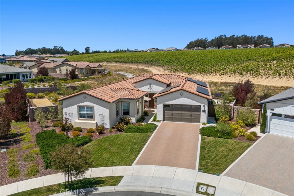 Enjoy the very best life has to offer in this spectacular Ventana home, set on a prime pie-shaped cul-de-sac lot with incredible outdoor space and a magnificent panoramic vineyard view - you have to see it to truly appreciate how special this property is! Built in 2021, this beautifully designed SOLAR home is packed with upgrades including engineered wood flooring, accordion wall of glass, gas fireplace with blower, solid core interior doors, custom bathroom mirrors, ceilings fans, and so much more. Starting in the culinary kitchen, you’ll be delighted with the white Shaker-style cabinetry, quartz countertops and island, industrial pendant lights, stainless appliances including GE Profile wall oven/microwave and induction cooktop and a walk-in pantry - it’s fresh, modern and super efficient. The great room has a cozy fireplace flanked with floating display shelves, and across the way is the large dining space - both offer magnificent vineyard views. Head outdoors through the accordion wall of glass to the covered patio and feast your eyes - the vineyard is front and center along with a built-in fountain, meandering decomposed granite pathways, vast gathering areas surrounded by olive trees for lounging and dining under the stars, and a regulation Bocce court - it’s a true vineyard setting and an amazing place for entertaining! Back inside, your owner’s suite awaits - a spacious bedroom with a sitting/lounging area and window seat with exceptional views; the spa-like en-suite bath features dual sinks with rubbed bronze fixtures, quartz counter, designer mirrors, linen storage, jetted tub, striking tile shower with two shower heads and seamless glass enclosure and a substantial walk-in closet. Your guests will be equally as comfortable up front with a bedroom and adjacent full bath, plus a Casita apartment with living room, bedroom, full bathroom and its own courtyard entrance. Additionally, there’s a private den overlooking the courtyard, a SmartSpace with laundry, sink, a powder room, 2-car garage with showroom epoxy floors, super high-tech HANS Premium Water filtration system, tankless water heater, an outlet for EV plug and A/C. You’ll probably never wish to leave this fabulous vineyard home, but when you do the resort-style amenities of Trilogy Monarch Dunes will be waiting for you.
