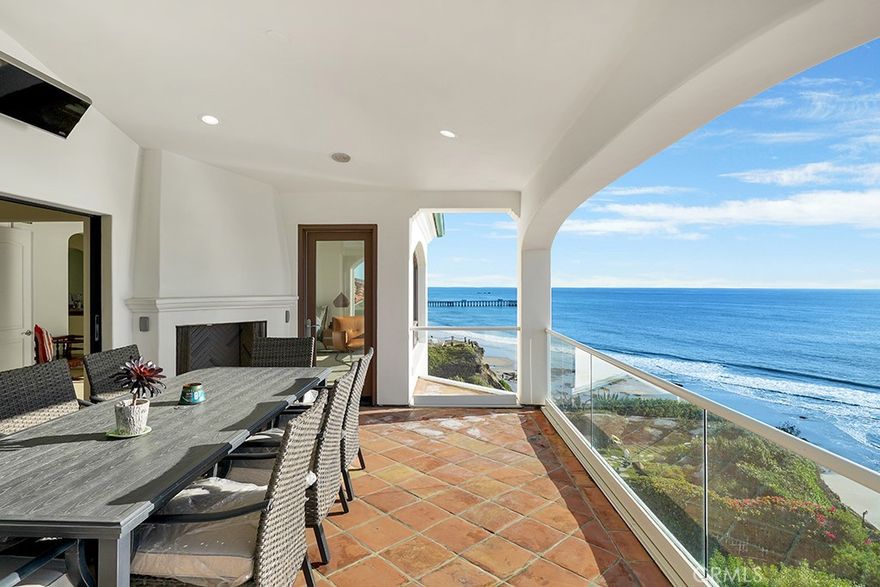 A sanctuary of quiet luxury, this stunning oceanfront penthouse in San Clemente is a rare opportunity to experience coastal living at its most refined. Set atop a secluded bluff in an intimate building of just three exclusive residences, the home offers direct access to breathtaking ocean panoramas, whitewater views, city lights, and the iconic San Clemente Pier. Spanning approximately 3,287 square feet on a single level, this exquisitely designed retreat is accessible via a private elevator or a grand spiral staircase in the courtyard. Thoughtfully composed to maximize its unrivaled oceanfront setting, the interiors unfold in a seamless open-concept design, where walls of glass invite the ever-changing Pacific horizon into everyday life. The kitchen, dining, and family rooms merge effortlessly, extending onto a sprawling ocean-view terrace with a fireplace—an idyllic setting for morning sunrises and golden-hour gatherings. Crafted for both grand entertaining and intimate living, the residence showcases bespoke finishes and meticulous attention to detail. The gourmet kitchen is a chef’s statement, appointed with a central island, walk-in pantry, skylight, granite countertops, and a suite of stainless-steel KitchenAid appliances, including a built-in refrigerator. A wet bar with wine refrigeration enhances the home’s effortless sophistication, while the elegant dining room—anchored by a fireplace and built-in cabinetry—sets the stage for unforgettable evenings. The primary suite is a private sanctuary, designed to frame breathtaking ocean views with direct terrace access. A custom walk-in closet, spa-like jetted tub, walk-in shower, and skylights complete the retreat. Secondary bedrooms, equally well-appointed, share a refined Hollywood bath, while an expansive media room—with vaulted ceilings, a balcony, and a corner fireplace—offers a stylish escape. One of only three residences in this boutique oceanfront enclave, the penthouse includes subterranean parking for four and an unparalleled location just moments from downtown San Clemente’s charming village, scenic parks, and renowned beaches. Offered fully furnished, with the option for partial or unfurnished arrangements, this is an extraordinary opportunity to inhabit one of San Clemente’s most exclusive coastal addresses. No pets allowed.