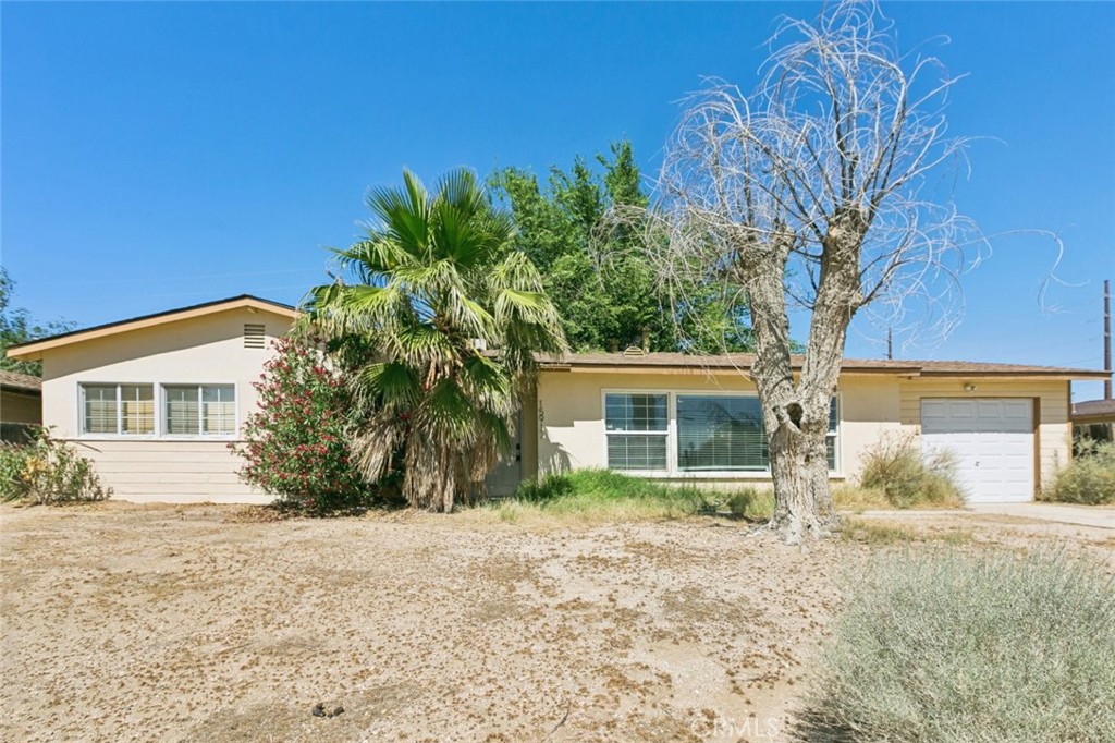 Now available in the heart of Mojave, this charming 3-bedroom, 1-bathroom single-story home offers 1,131 square feet of bright and functional living space. The spacious layout includes a generous living area filled with natural light from expansive windows, and a dedicated dining area that flows seamlessly into the kitchen. The kitchen features ample cabinetry, durable tile flooring, and direct access to a separate laundry area with washer and dryer included. Each bedroom is comfortably sized with closet storage, and the full bathroom includes a dual-sink vanity and classic finishes. Additional highlights include central heating and cooling, ceiling fans, and neutral paint throughout. Outside, enjoy a large front yard, a private driveway, and an attached one-car garage. With its blend of comfort, practicality, and location, this residence is an excellent option for those seeking long-term living or a smart investment opportunity in a peaceful residential neighborhood.