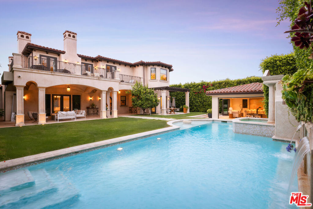 Inspired by Andrea Palladio and built to exacting standards 617 N Camden is a custom built, nearly 12,000 sqft estate, that marries the symmetry and proportion of Italian Renaissance design with the warmth of Mediterranean refinement. A residence of this proportion cannot be replicated and is one of the most important offerings in the Beverly Hills Flats. Privately gated on prime 600 block featuring hand-carved arches, soaring volumes, and sculptural finishes that echo the timeless elegance of Pelican Hill. The two-story foyer makes an immediate statement with its dramatic ceiling height, inlaid stone medallion flooring, custom wall insets ideal for curated art, and a sweeping staircase crowned by a wrought iron skylight. The main level is designed for elevated entertaining, featuring a formal living room with a carved stone fireplace and coffered ceiling, a richly paneled Presidential office with floor-to-ceiling built-ins, formal dining room, chef's kitchen with Viking appliances and illuminated stone counters, and a family room that opens directly to the backyard. Upstairs, the primary suite offers a fireplace, private sitting area, balcony overlooking the grounds, a stone-wrapped bath with soaking tub and steam shower, and a custom walk-in closet. Three additional en-suite bedrooms and a second family room complete the upper level. The lower level is designed for true leisure and indulgent hosting, with a private 12-seat theatre featuring a Rolls-Royce inspired bespoke Starlight headliner and backlit onyx snack bar. A full wellness retreat with gym, sauna, steam, and massage room is accented by a game room, full bar, 1,000-bottle temperature controlled wine cellar and outdoor atrium. Outdoors, the grounds are wrapped in privacy hedging and citrus trees. A resort-style pool with water features and fire pit is framed by a covered loggia with fireplace and outdoor TV, alongside a pool house lounge ideal for entertaining. Additional amenities include a sprite maids quarters, elevator, a full Crestron smart home system controlling lighting, AV, pool, and security. 617 N Camden Drive is a rare opportunity to own a timeless, irreplaceable estate in one of most coveted enclaves in Beverly Hills.