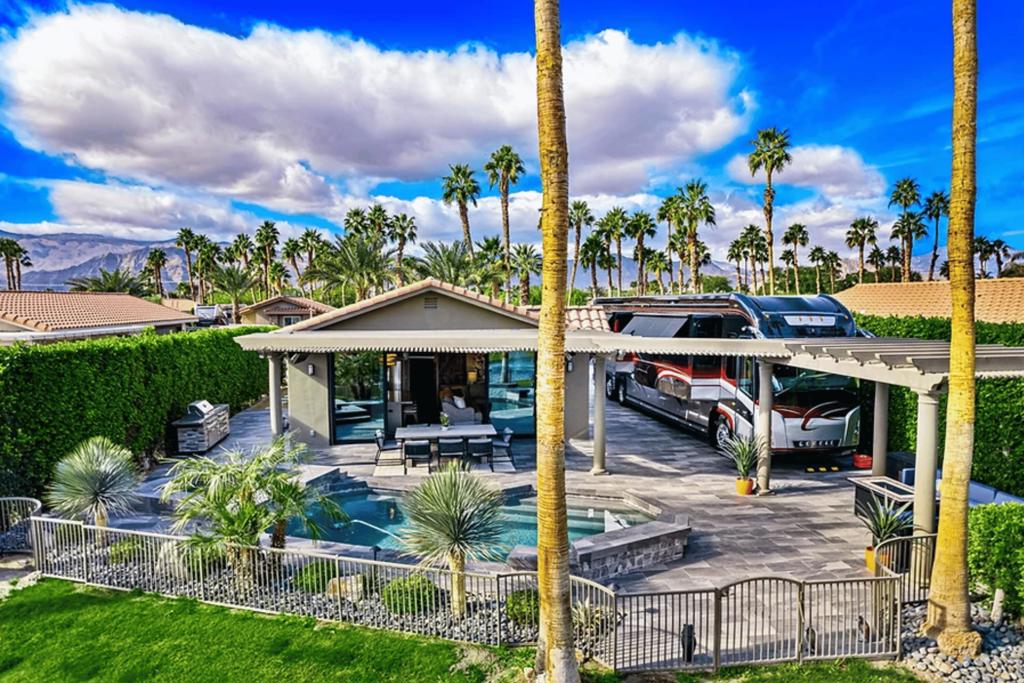 Discover unparalleled luxury at Lot 63 E. Balboa Place in the prestigious Desert Shores Motorcoach Resort. This meticulously renovated property blends modern elegance with serene lakeside living, offering breathtaking eastern exposure with views of the lake, fountain, and Shadow Hills. Designed for relaxation and entertainment, this move-in-ready lot delivers the ultimate motorcoach lifestyle. Step into your private oasis, where a beautifully refinished pool & spa feature cascading spillways, updated tile, pebble plaster, and modern equipment. Expansive porcelain tile decking extends across the patio and driveway, creating a seamless outdoor living space. The primary covered patio is equipped with a waterproof cover, electric heaters, recessed lighting, and a ceiling fan, while a secondary covered patio and portable BBQ station enhance your entertainment options. A smooth stucco exterior, metal Bahama awnings, wrought iron fencing, and low-maintenance desert landscaping--highlighted by majestic 15+ ft. date palms--elevate the property's curb appeal. Inside, every detail exudes sophistication. The gourmet kitchen features shaker cabinets, quartz countertops, a designer backsplash, farmhouse sink, stainless steel appliances, and a spacious walk-in pantry. The great room showcases luxury vinyl plank flooring, faux wood beams, a linear fireplace flanked by custom cabinetry, crown molding, and an 18-ft. stacking slider glass door for seamless indoor-outdoor flow. The en suite retreat boasts dual vanities, an oversized shower, private water closet, and a walk-in closet with built-in organizers. A separate den with a recessed workspace adds versatility for work or relaxation. Designed with state-of-the-art technology, this property includes upgraded plumbing with an on-demand tankless water heater, LED lighting, Lutron smart controls, and a 10-camera security system with remote access. Additional features include 8-ft. solid core doors, custom barn doors, smooth drywall finishes, and quartz countertops throughout. The climate-controlled garage offers split-system AC/heating, epoxy flooring, and washer/dryer space for ultimate convenience. With 1,210 sq. ft. of total living space (810 sq. ft. enclosed), this fully furnished, turn-key property is move-in ready. HOA dues cover landscaping, lake maintenance, 24-hour security, lawn care, high-speed internet, and community amenities. Desert Shores is a Class A Motorcoach Resort for 36'-45' motorcoaches only.