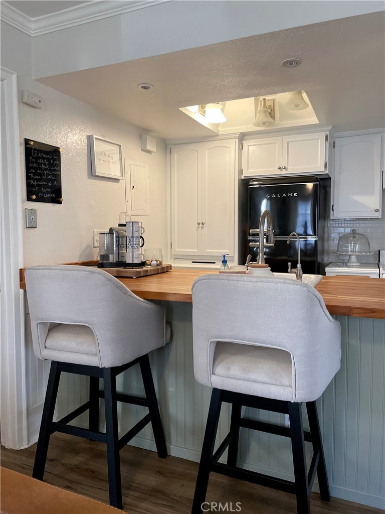 Move-in ready single-level condo with no interior steps! This beautifully maintained downstairs unit offers 2 bedrooms, 2 bathrooms, and 2 covered assigned carports. It has been re-piped with PEX, it features stylish vinyl wood flooring throughout and a light-filled open concept floor plan.
The updated kitchen boasts elegant two-tone cabinetry, a butcher block countertop, a newer hood, and a custom oversized pantry. Both bathrooms feature upgraded vanities with stone countertops. Enjoy added comfort with window shades throughout, plus a drop-down shade on the private patio for cooling and privacy.
The primary suite offers a walk-in closet, while the secondary bedroom includes floor-to-ceiling custom closets for maximum storage—each bedroom comes with its own private bathroom. Additional highlights include inside laundry, crown molding, wainscoting, central AC, and available dishwasher hookups next to the sink.
Community amenities include two pools, and residents have the option to join Lake Mission Viejo for summer concerts, boat rentals, and a private beach with concessions. HOA covers water and trash, and the community is FHA and VA-approved. Ideally located near shopping, dining, and entertainment.