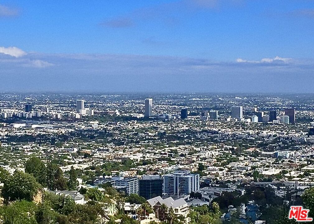 Dramatic view estate showcasing jetliner panoramas from downtown to the Pacific. Discreetly set on a coveted cul-de-sac off Lower Sunset Plaza Drive, within the iconic Sunset Strip above Sunset Boulevard. This 5,586 sq. ft. residence features 6 bedroom suites plus a private office, digital home theater, billiards/game room with bar, multiple fireplaces, and a sauna. The residence is enhanced by a private elevator, offering convenient access to all floors, including the rooftop.The primary suite includes a fireplace, two balconies, and a spa-inspired bath with steam shower, spa tub, and oversized walk-in closet. Two lower-level bedrooms enjoy private entrances, and the home is equipped with a state-of-the-art automation system (Control4). A 1,000 sq. ft. rooftop lounge crowns the home, showcasing panoramic city views, while a tropical pool and spa create a private resort-style retreat. The gourmet kitchen is highlighted by a dramatic skylight, dual Sub-Zeros, two dishwashers, a six-burner gas range with double ovens, an induction cooktop, microwave, and wine refrigerator. High ceilings and expansive dining and living areas further enhance the home's open, modern design. Offered individually at $4,650,000, or together with neighboring 8835 Evanview for $9,300,000 an extraordinary opportunity to secure dual adjacent estates above the Sunset Strip. Distinctive as a stand-alone residence or elevated further when combined as a compound, the offering aligns with both lifestyle enjoyment and wealth-placement strategies, including 1031 exchanges. An irreplaceable financial and architectural statement in the Hollywood Hills.