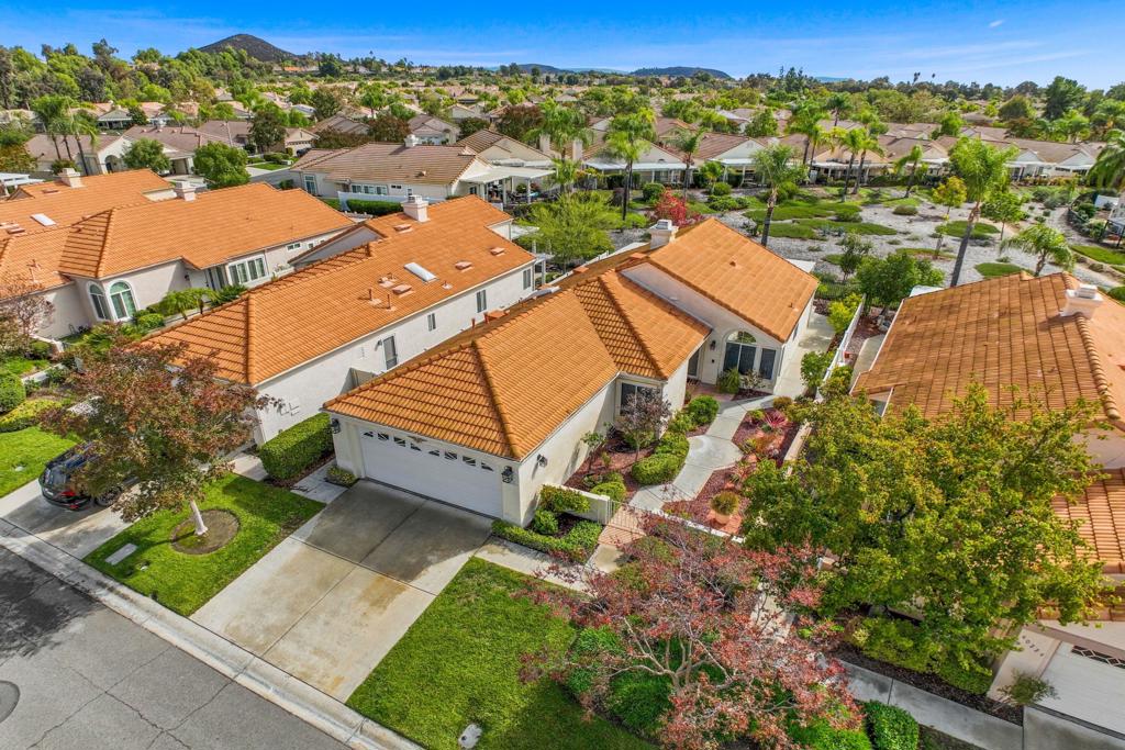 Designer Lives Here! It feels like a brand new home. Fully Upgraded 2 bedroom 2 bath Single-Story Greenbelt Home in The Colony - one of Southern California's most sought-after 55+ gated communities offering resort-style amenities and 24-hour guard-gated security. Stunning, meticulously remodeled home, where every square inch has been transformed with exquisite craftsmanship & attention to detail. Enjoy the convenience of nearby shopping and dining, including Historic Downtown Murrieta, as well as the renowned Temecula Wine Country...all just moments away. You enter the property through the beautiful landscaped gated walkway. Inside, you'll find tile wood-look flooring, vaulted ceilings, and an abundance of natural light in the expansive great room with an impressive fireplace featuring a custom shiplap surround. A large sliding glass door leads to your east-facing patio, perfect for morning coffee with tranquil greenbelt views, and afternoon shade for relaxing or entertaining. The Remodeled kitchen features crisp white cabinetry, added pantry & new Stainless appliances. Primary Suite Retreat - The spacious primary bedroom boasts a vaulted ceiling, ceiling fan & direct patio access. The Remodeled ensuite bathroom includes dual sinks, an oversized designer tiled walk-in shower, a walk-in closet & additional storage. ADDITIONAL HIGHLIGHTS: Recessed LED Lighting throughout. EV Charger installed in Garage. Guest bathroom is remodeled with stunning designer tile. Step outside onto your private patio and take in the views of the open space that lies just beyond your home. Relax under the Alumawood cover & delight in the presence of your very own peach, lemon, and orange trees. Say goodbye to the hassle of front yard maintenance, as the HOA takes care of it all, including watering the lawn. COMMUNITY: The state-of-the-art clubhouse offers a grand ballroom, fitness center, library, beauty salon & billiards room. The clubhouse serves as the vibrant heart of this community. Outdoor enthusiasts will find a wealth of recreational options at their fingertips. Swimming pool, engage in friendly matches on the pickleball, tennis, bocce ball & shuffleboard courts. And for golf enthusiasts, the neighboring Cal Oaks Golf Course winds its way through the community, providing magnificent views & endless enjoyment. The Colony homeowners voted to purchase the golf course & if the HOA wins the bid, there will be a ONE-TIME assessment of $1,995 per home.