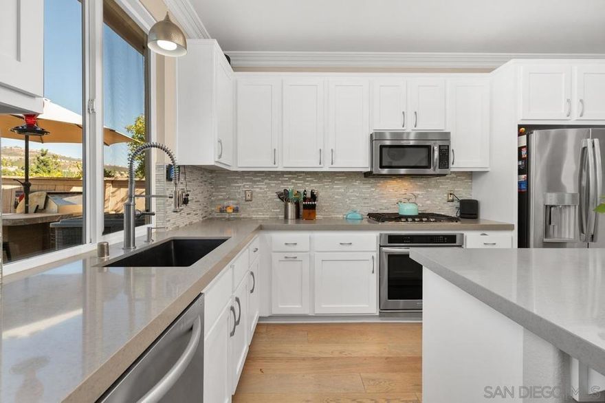 Experience the essence of refined single-story living with an upstairs loft in this beautifully upgraded San Elijo Hills home, where comfort, style, and energy efficiency meet seamlessly. Ideally located within walking distance to top-rated schools, scenic parks, restaurants, coffee shops, and the vibrant town center, this residence offers the perfect blend of luxury and community. The open-concept layout features four bedrooms and three full baths, including a spa-inspired primary suite and two additional bedrooms on the main level. The gourmet kitchen is a chef’s dream, showcasing sleek gray quartz countertops, a custom backsplash, shaker cabinetry, premium KitchenAid appliances, and a spacious center island perfect for entertaining. Elegant French oak wood floors, crown molding, a cozy stone fireplace, and smart-home lighting create a warm yet sophisticated ambiance. The luxurious primary suite features a glass-enclosed rain shower, soaking tub with a serene waterfall feature, and a custom walk-in closet. A versatile downstairs office or guest room with a built-in Murphy bed adds flexibility, while the upstairs loft with its own bedroom and bath offers an ideal retreat for guests or multi-generational living. Thoughtful details include a custom bookcase pantry, built-in storage, powered blackout shades, and air conditioning for year-round comfort. Step outside to an expansive backyard with panoramic views, a built-in firepit, and a sleek aluminum patio cover—perfect for relaxing or entertaining. With a low $90/month HOA, this stunning home has Solar that is paid.