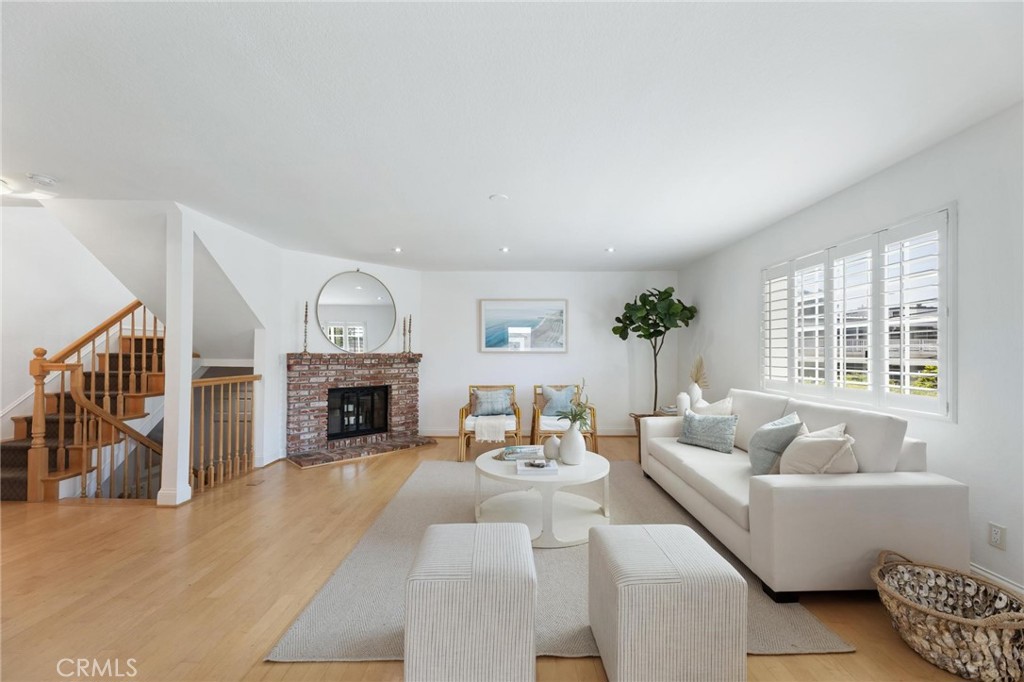 Welcome to 1421 12th Street, Unit 1, a bright and airy front townhome in a quaint Cape-Cod style building. Flooded with natural light, this home features an open floor plan where the kitchen, dining, and living spaces connect seamlessly. Off the dining area, sliding glass doors open to a spacious terrace, perfect for outdoor dining or lounging. The updated kitchen showcases stainless steel appliances, new stone countertops, refaced cabinetry, and fresh paint. Additional highlights on the main level include hardwood floors throughout, a brick fireplace, and a convenient powder room. Upstairs, two bedrooms each enjoy their own ensuite bath and large closets, creating a versatile dual-primary layout. One bedroom also features a private terrace with room for seating and lounging. The lower level provides direct access to a two-car garage with ample storage. This special property (one of only five units) is a quiet escape, located just one block from Meadows Elementary, Polliwog Park, and Manhattan Beach Middle School. Manhattan Beach Preschool is also just around the corner. With easy access to downtown shops and dining, plus LAX and major freeways just minutes away, this location is ideal for both convenience and lifestyle.
